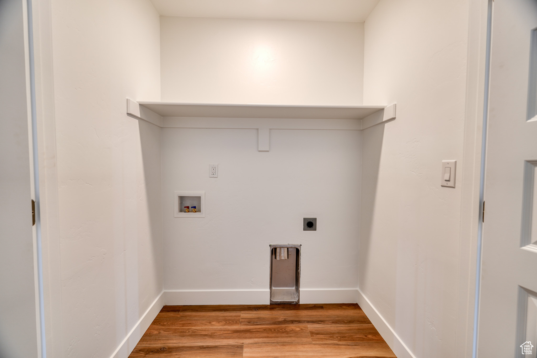 Laundry room featuring washer hookup, hookup for an electric dryer, and light hardwood / wood-style flooring