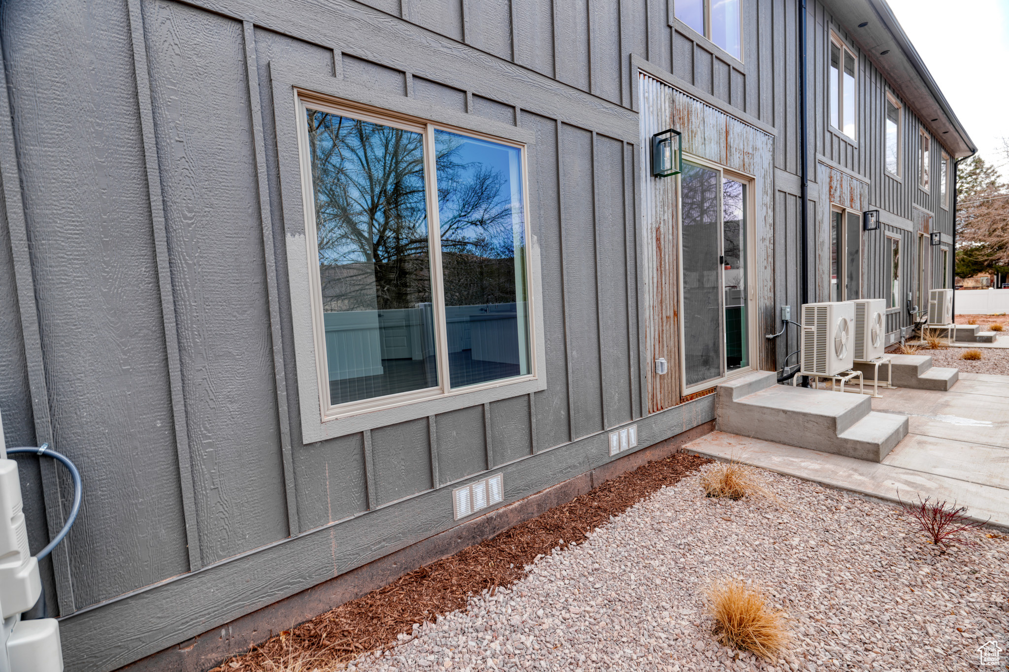 View of side of property with ac unit and a patio area