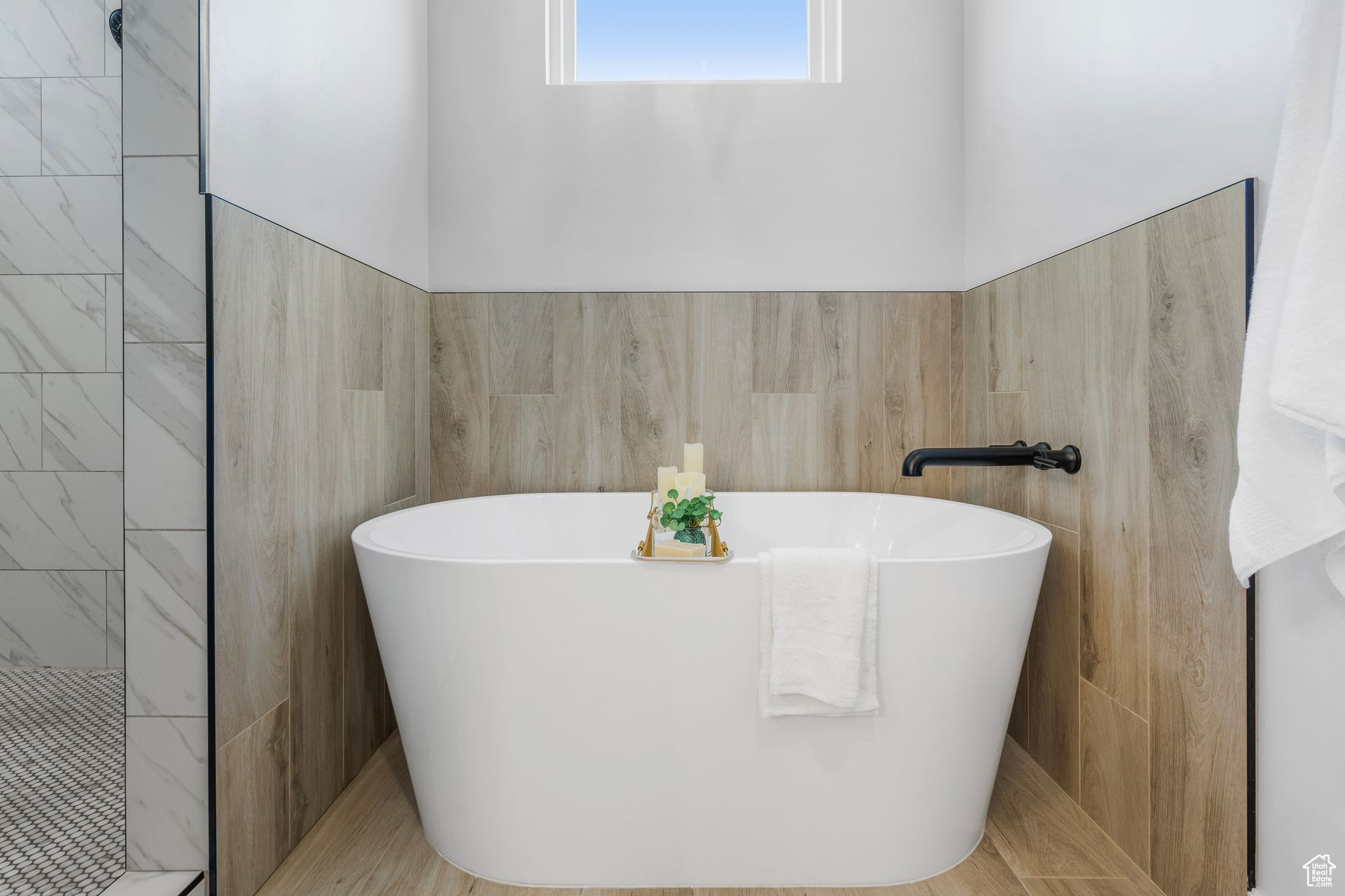 Bathroom featuring a washtub and tile walls