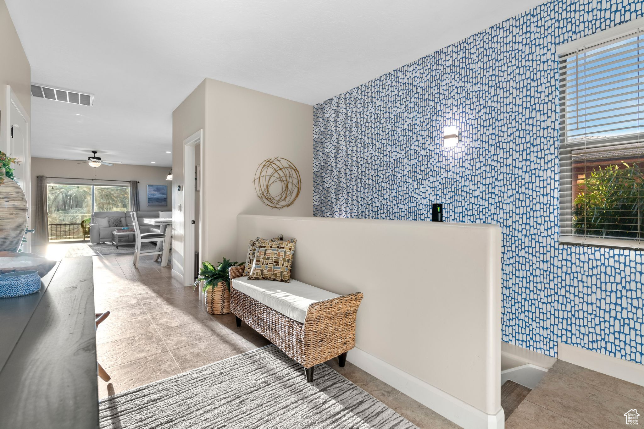 Interior space featuring ceiling fan and tile walls