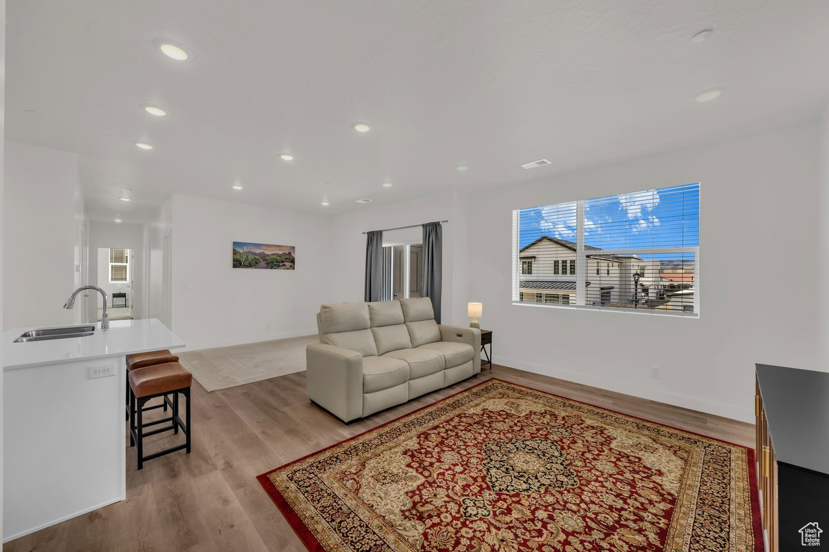 Living room featuring plenty of natural light, sink, and light wood-type flooring