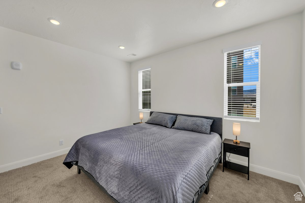 Bedroom featuring light carpet