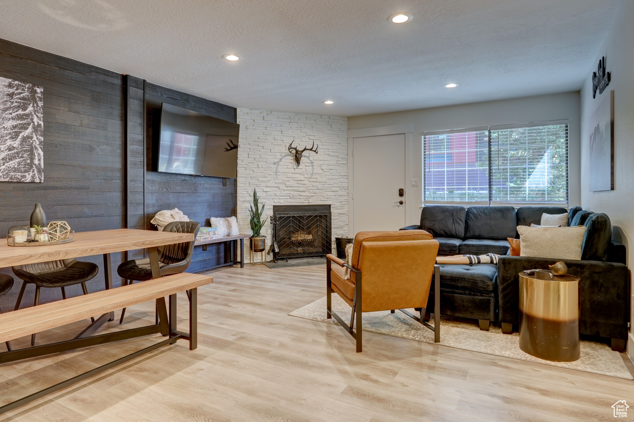 Living room with a fireplace, light hardwood / wood-style floors, and a textured ceiling