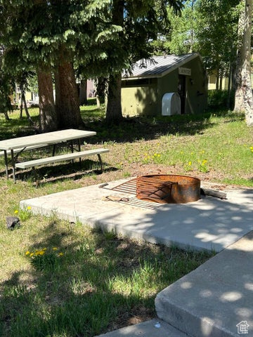 View of property's community featuring a picnic bench and fire pit