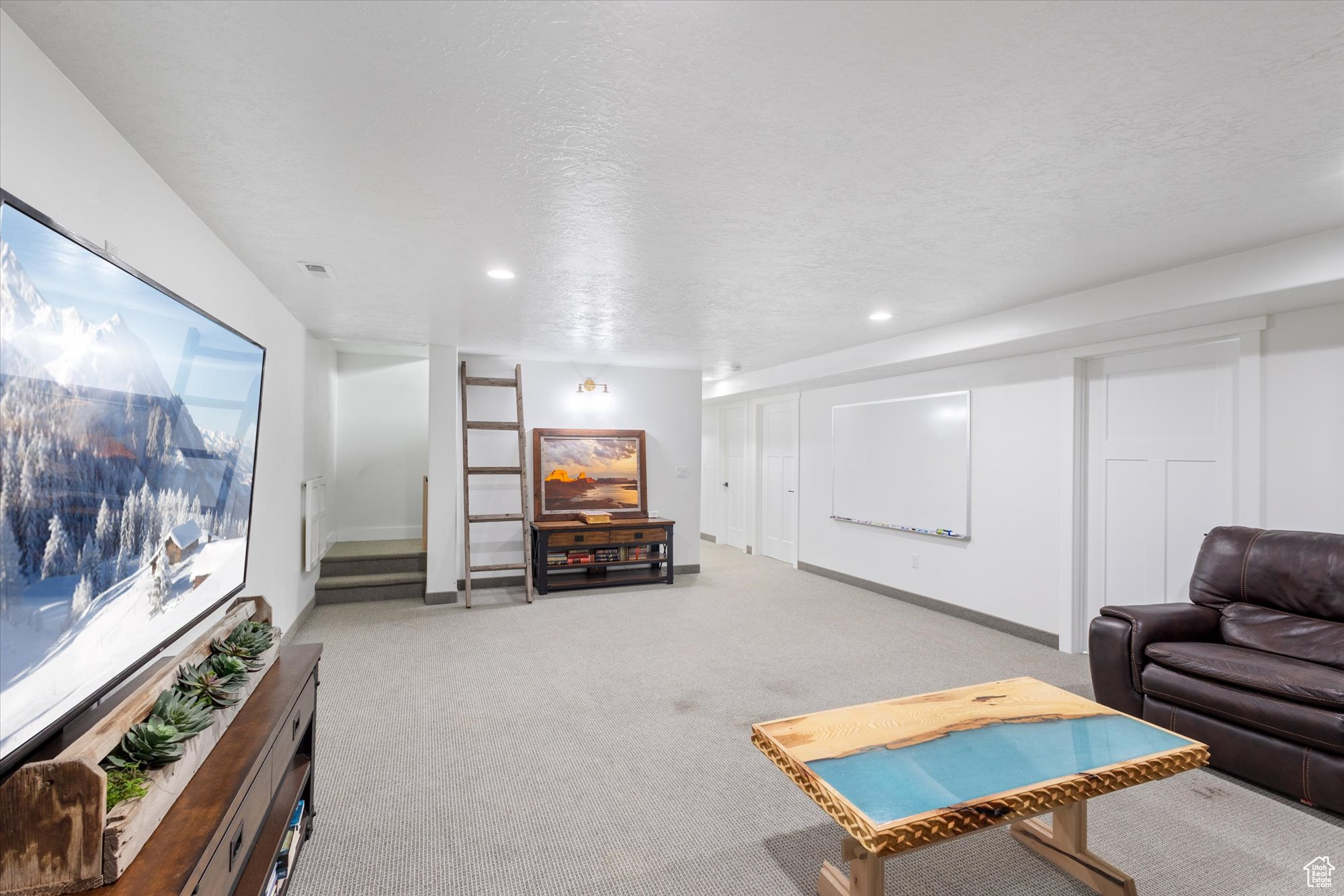 Living room with light colored carpet and a textured ceiling