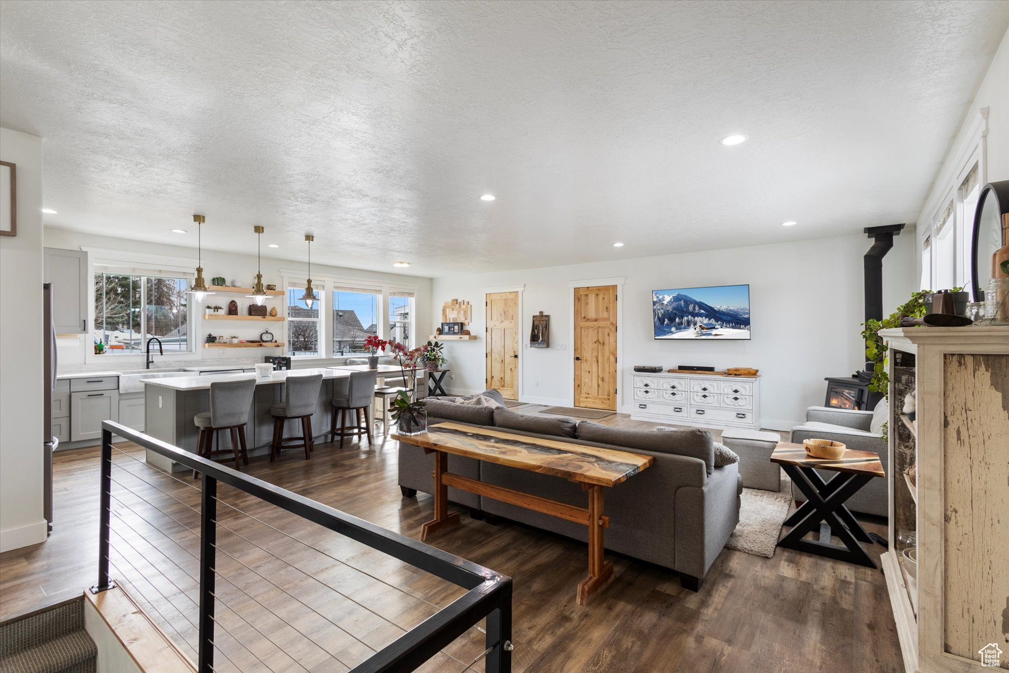 Living room with hardwood / wood-style flooring, sink, and a textured ceiling