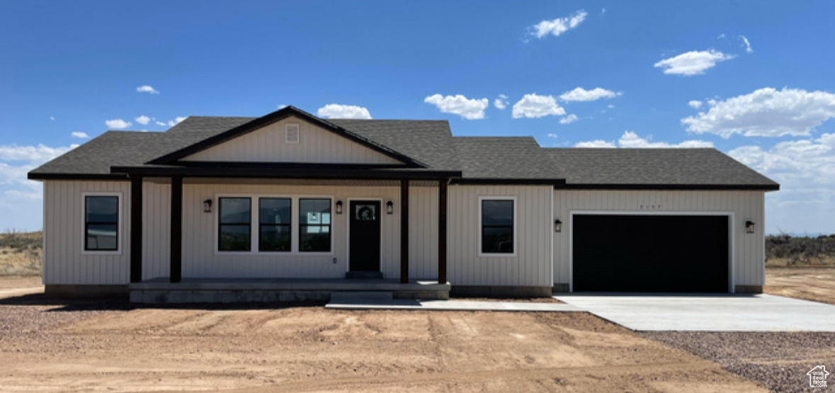 View of front of home featuring a garage and a porch