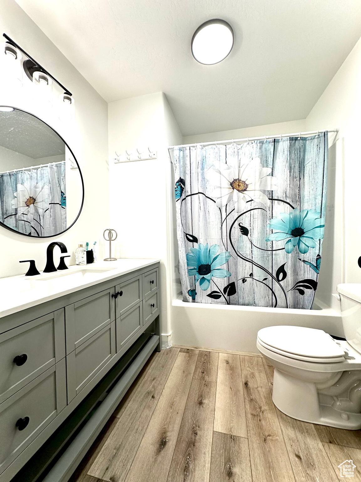 Master bathroom featuring vanity, toilet, hardwood / wood-style floors, and shower / bath combo with shower curtain