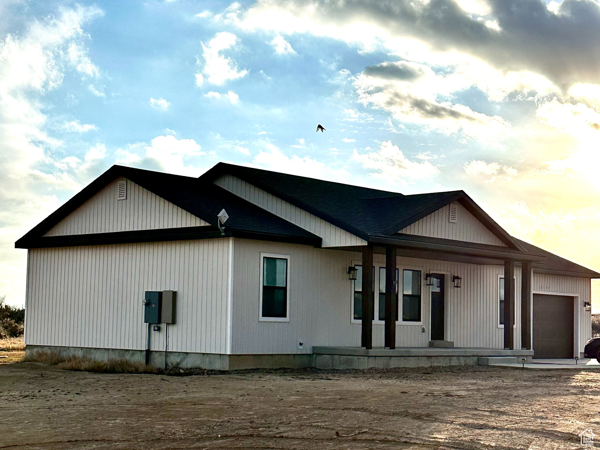 View of front facade featuring a garage and a porch