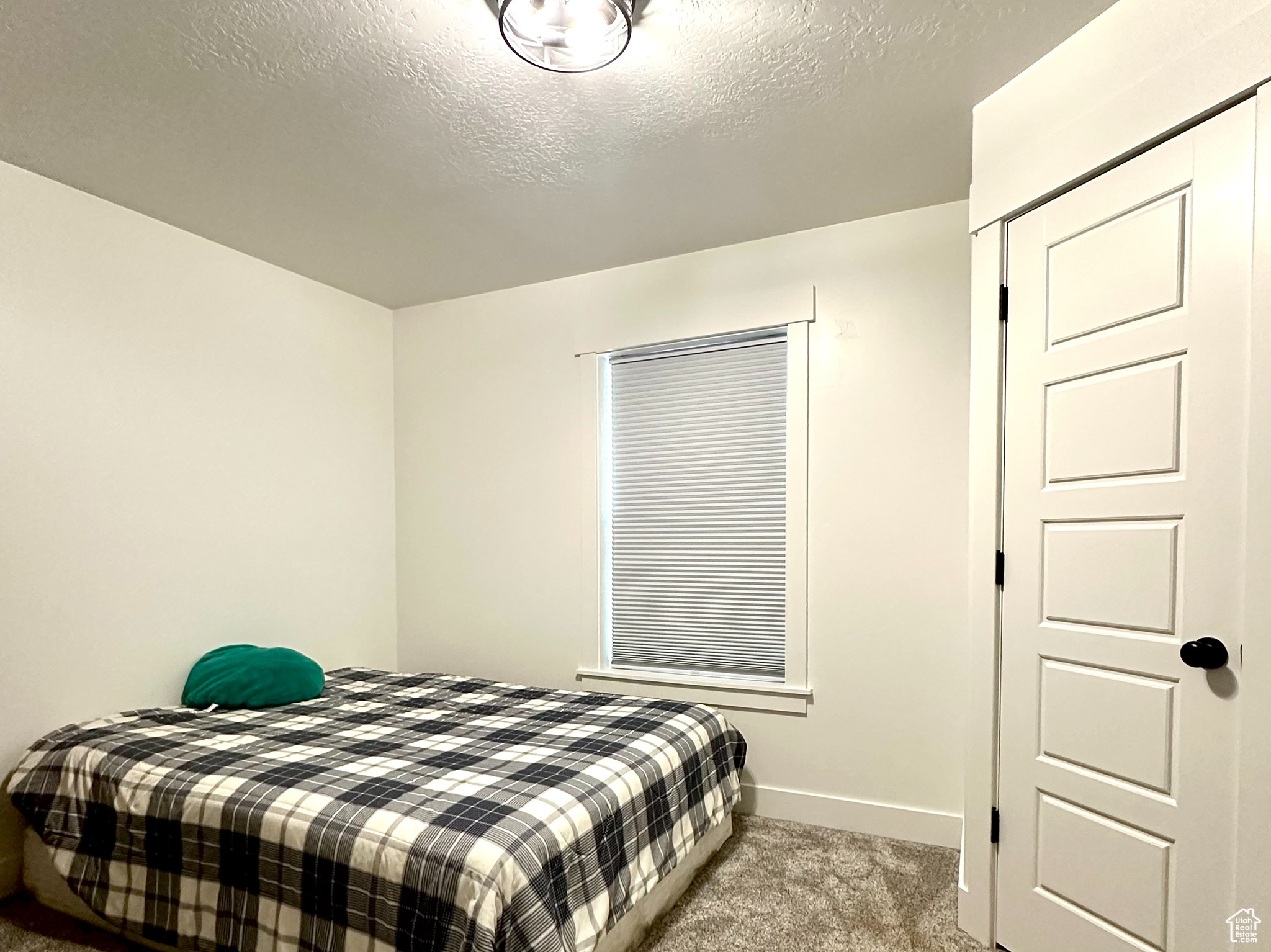 Bedroom 2 featuring carpet floors and a textured ceiling