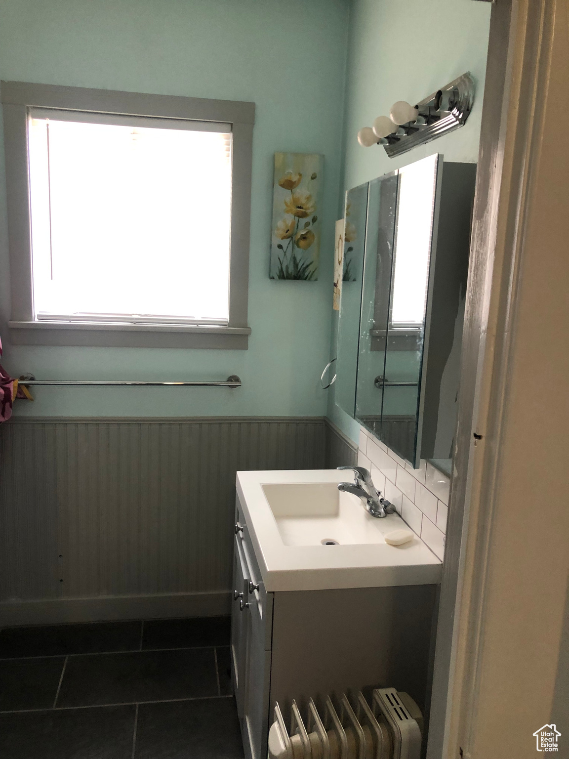 Bathroom with vanity, radiator heating unit, tile patterned floors, and wood walls