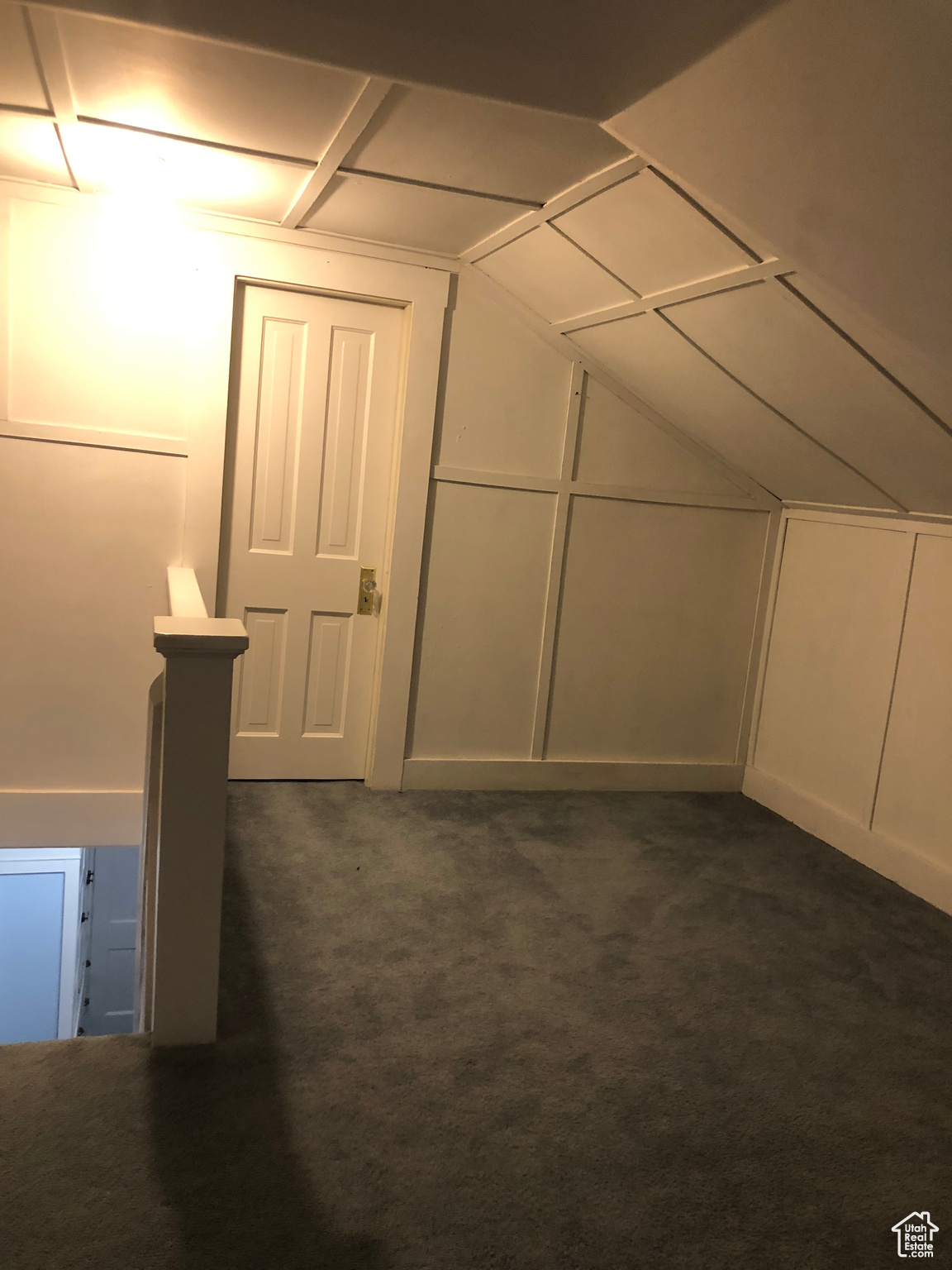 Additional living space with vaulted ceiling and dark carpet