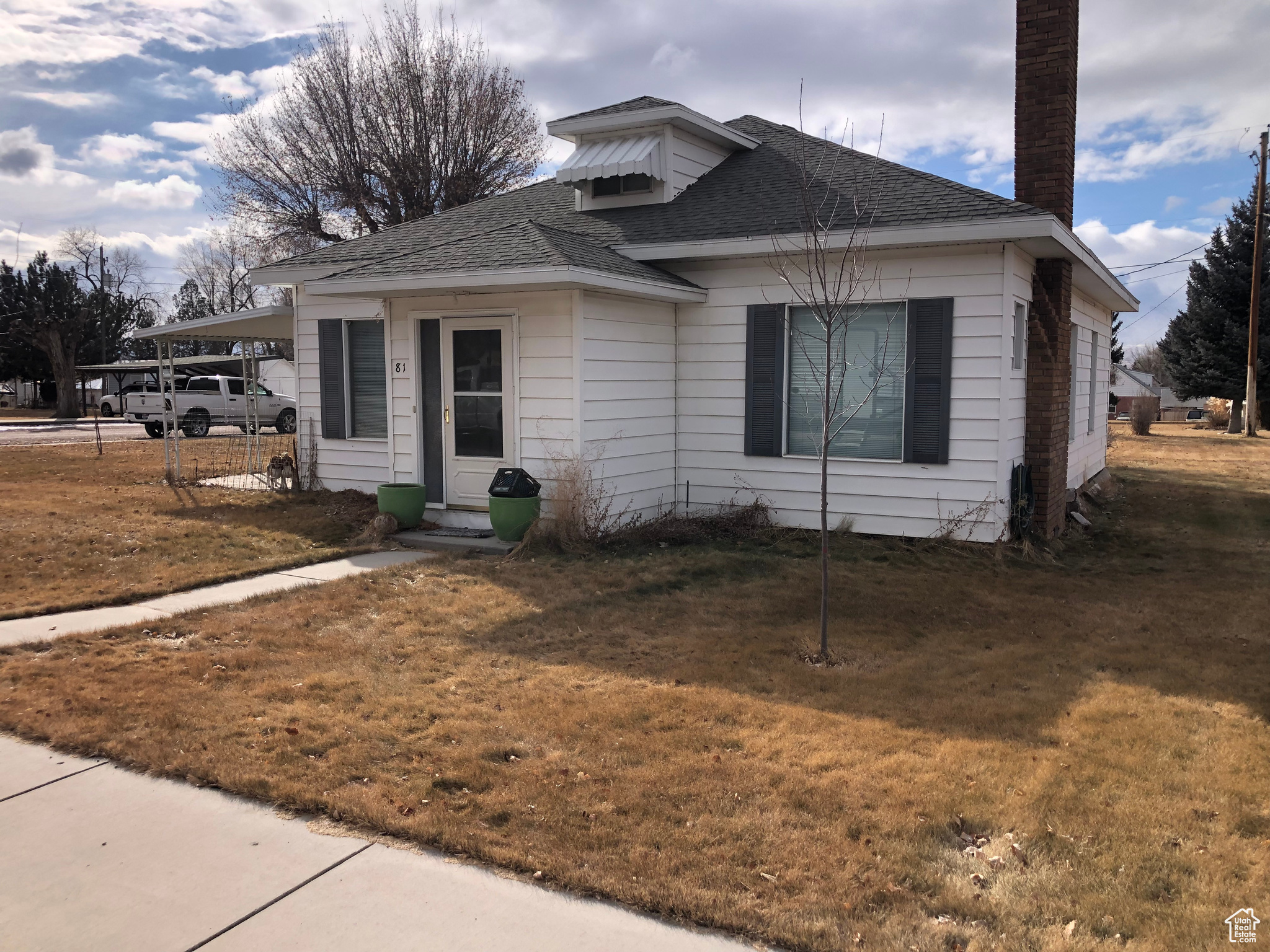 Bungalow-style house with a front lawn and a carport
