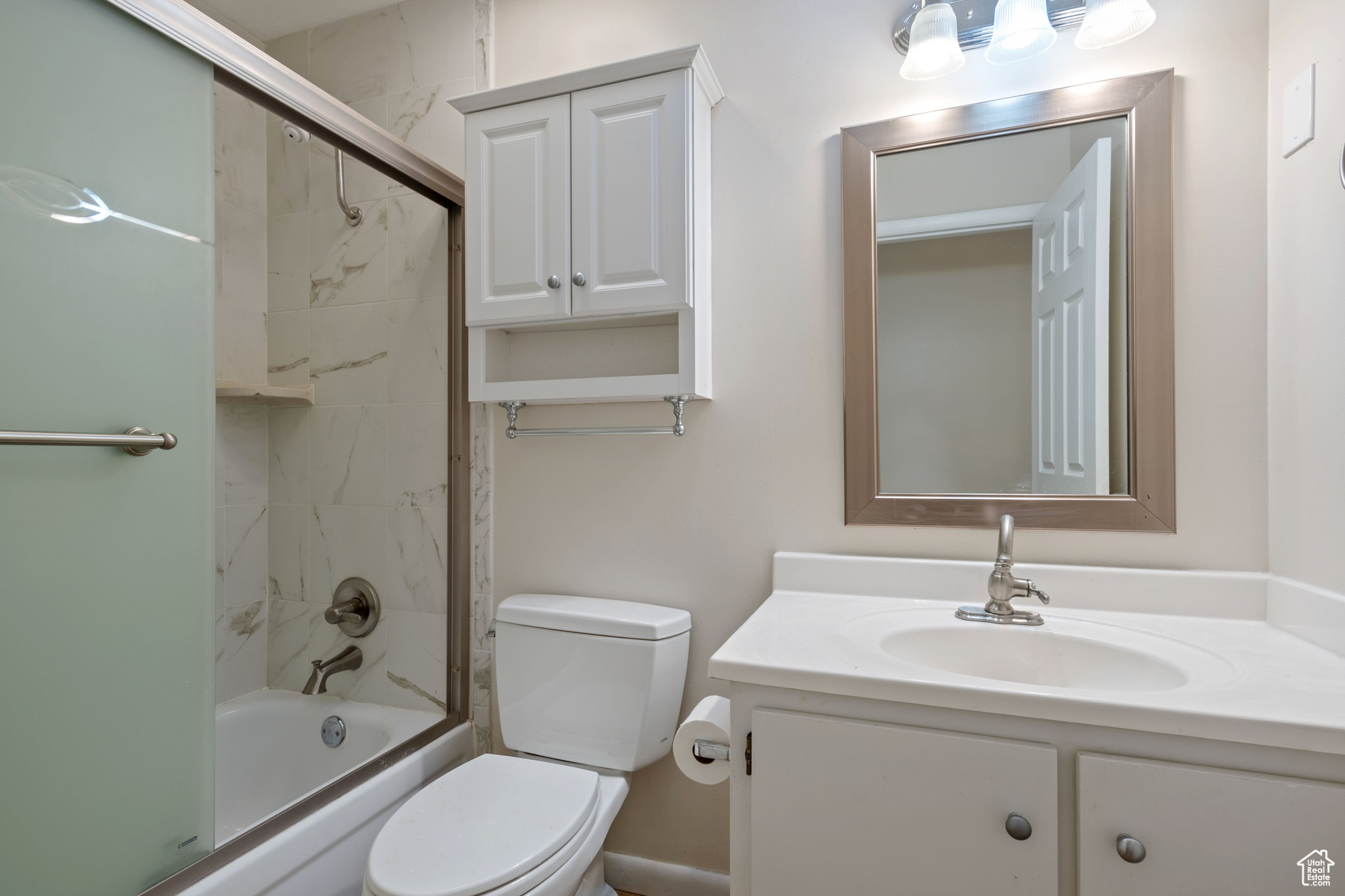 Full bathroom featuring vanity, toilet, and combined bath / shower with glass door