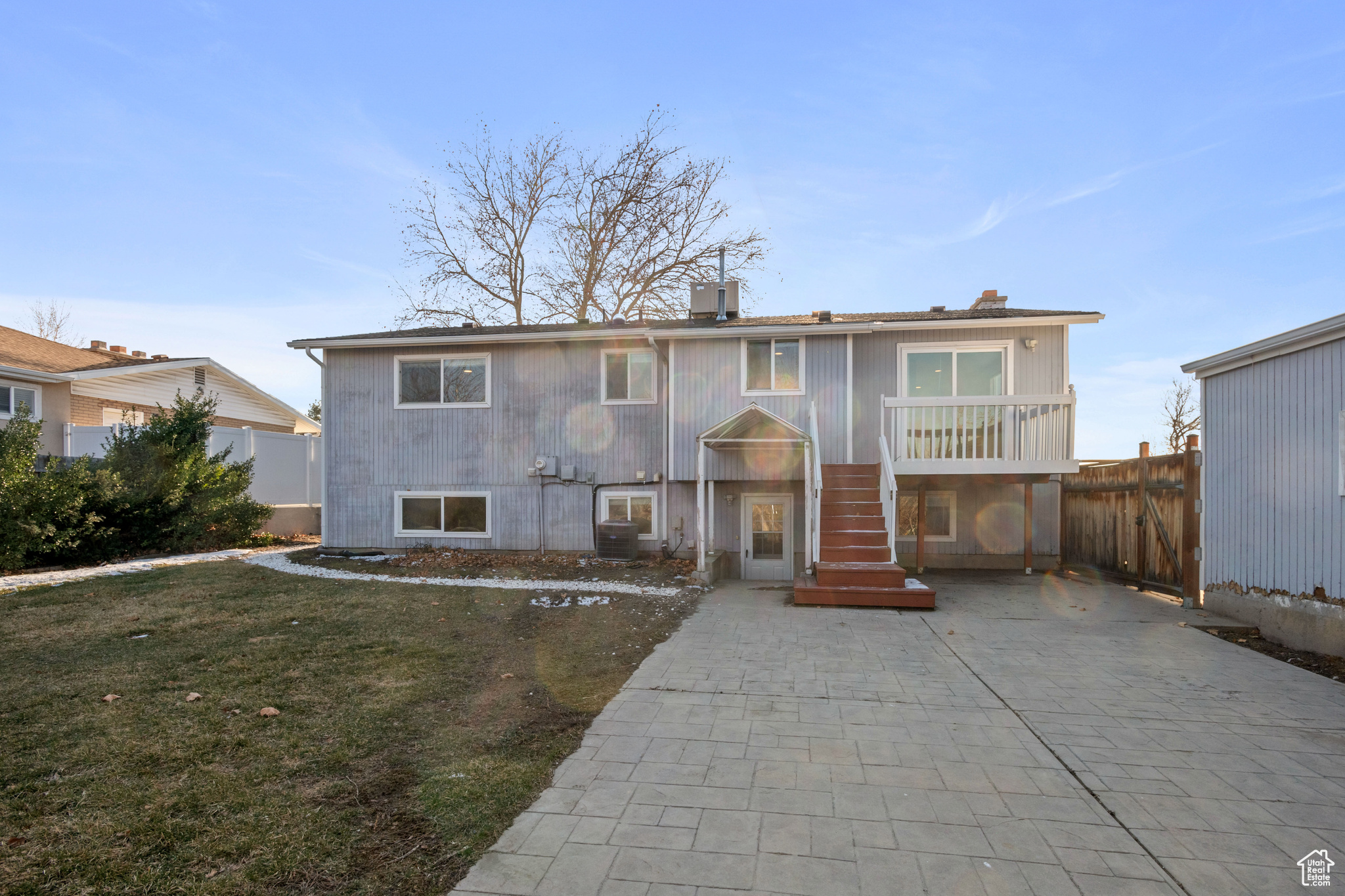 View of front of home featuring a patio, central air condition unit, and a front lawn