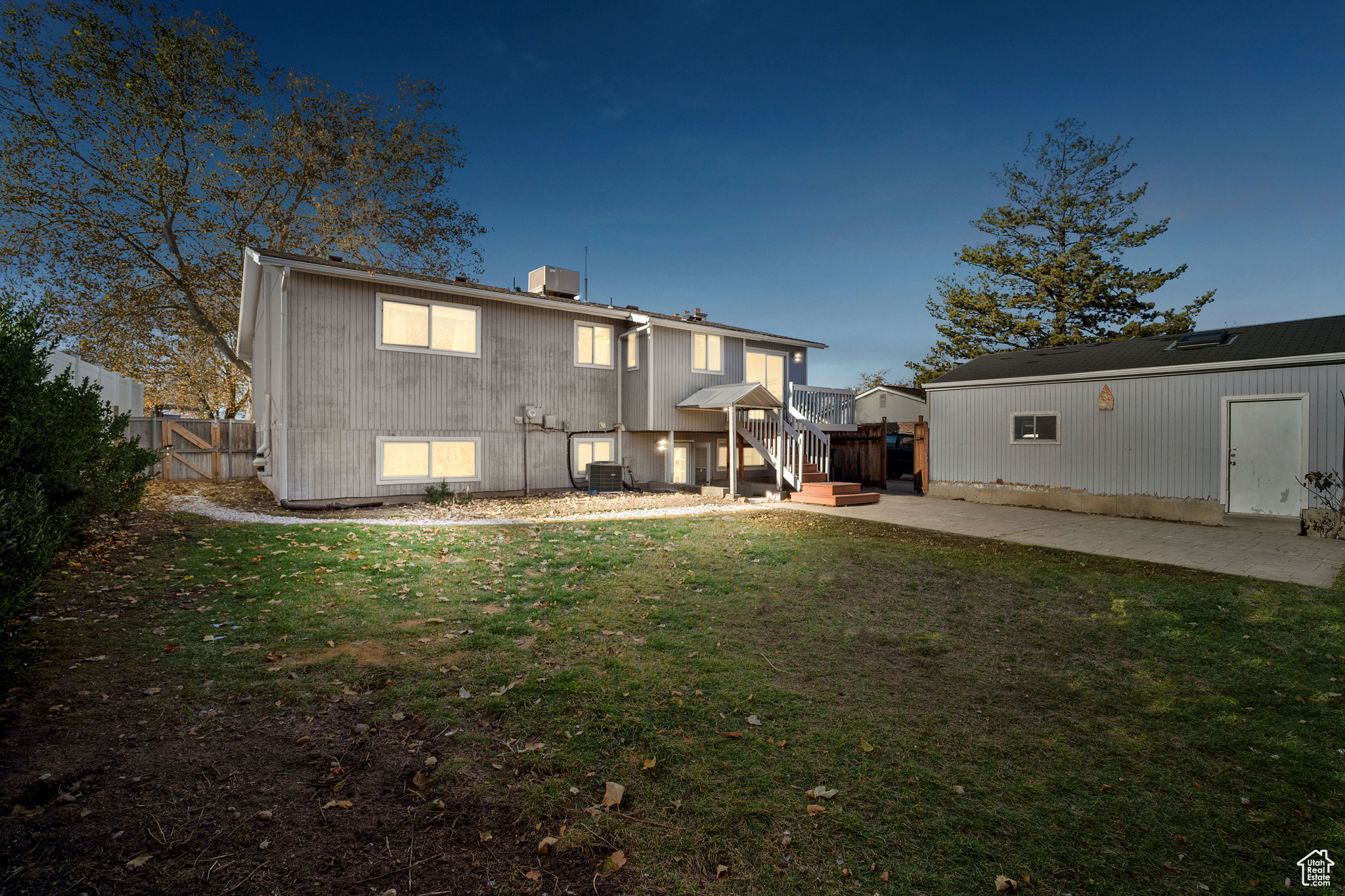 Back house at dusk with a patio and a yard