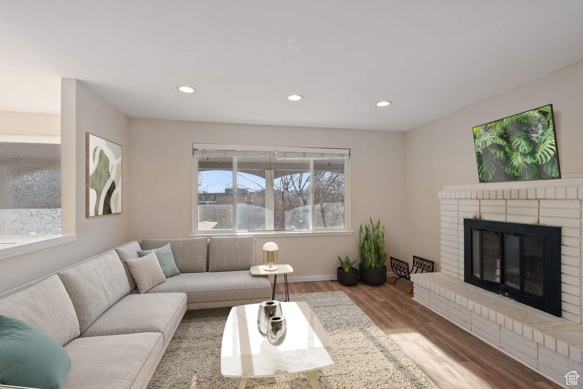Living area with baseboards, a brick fireplace, wood finished floors, and recessed lighting