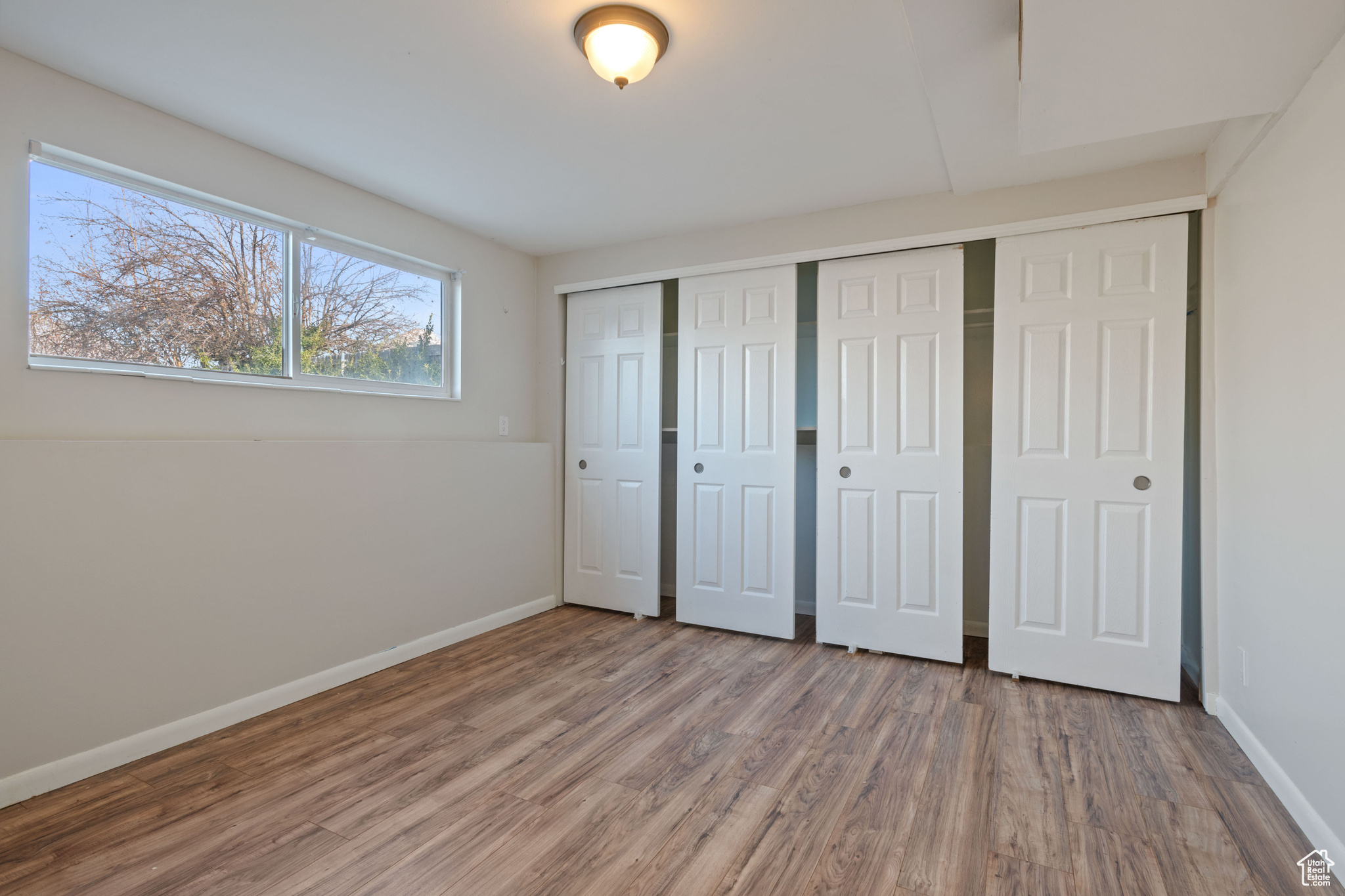 Unfurnished bedroom featuring hardwood / wood-style floors and a closet