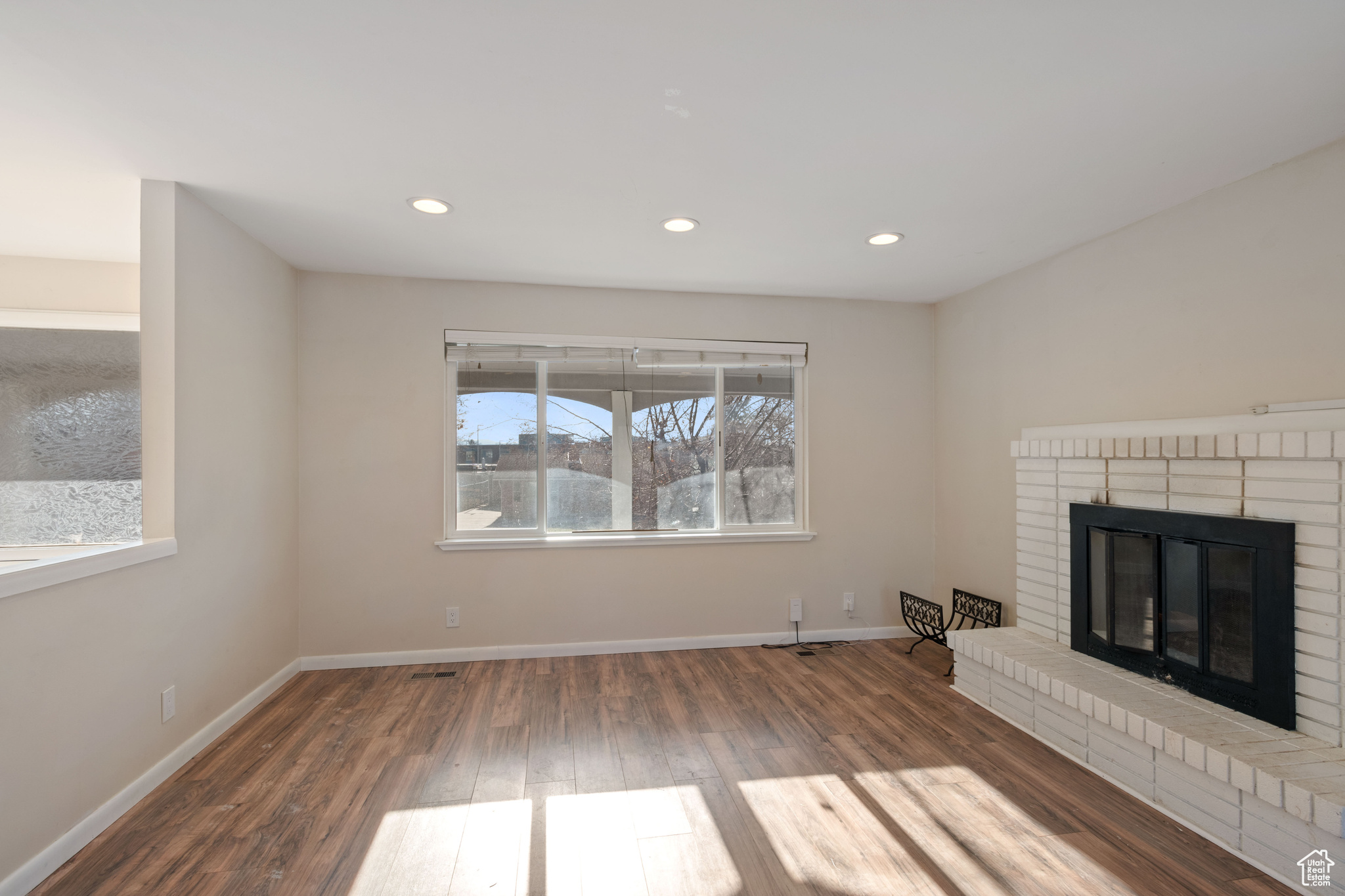 Unfurnished living room with hardwood / wood-style flooring and a fireplace
