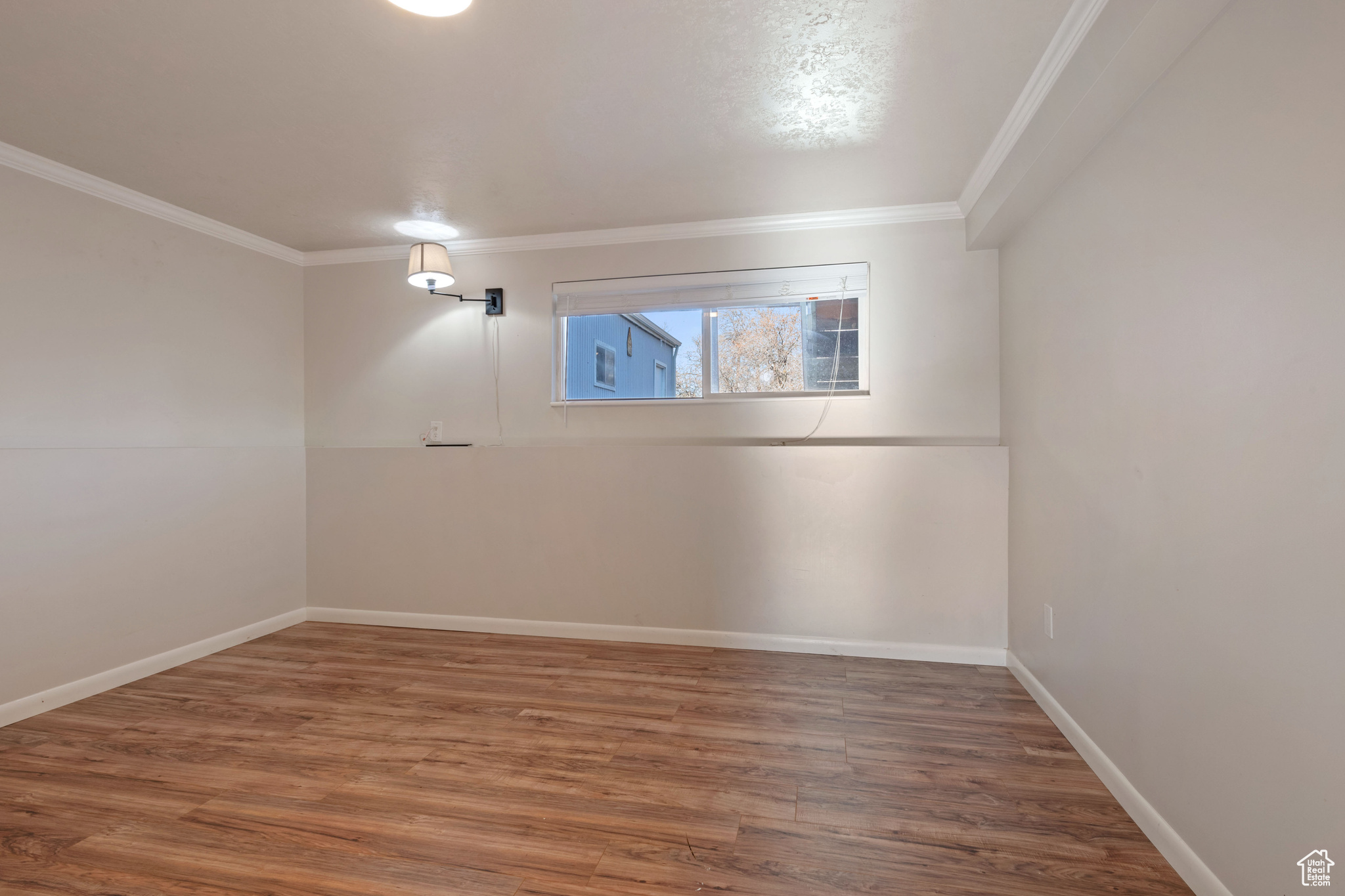 Empty room with dark wood-type flooring and ornamental molding