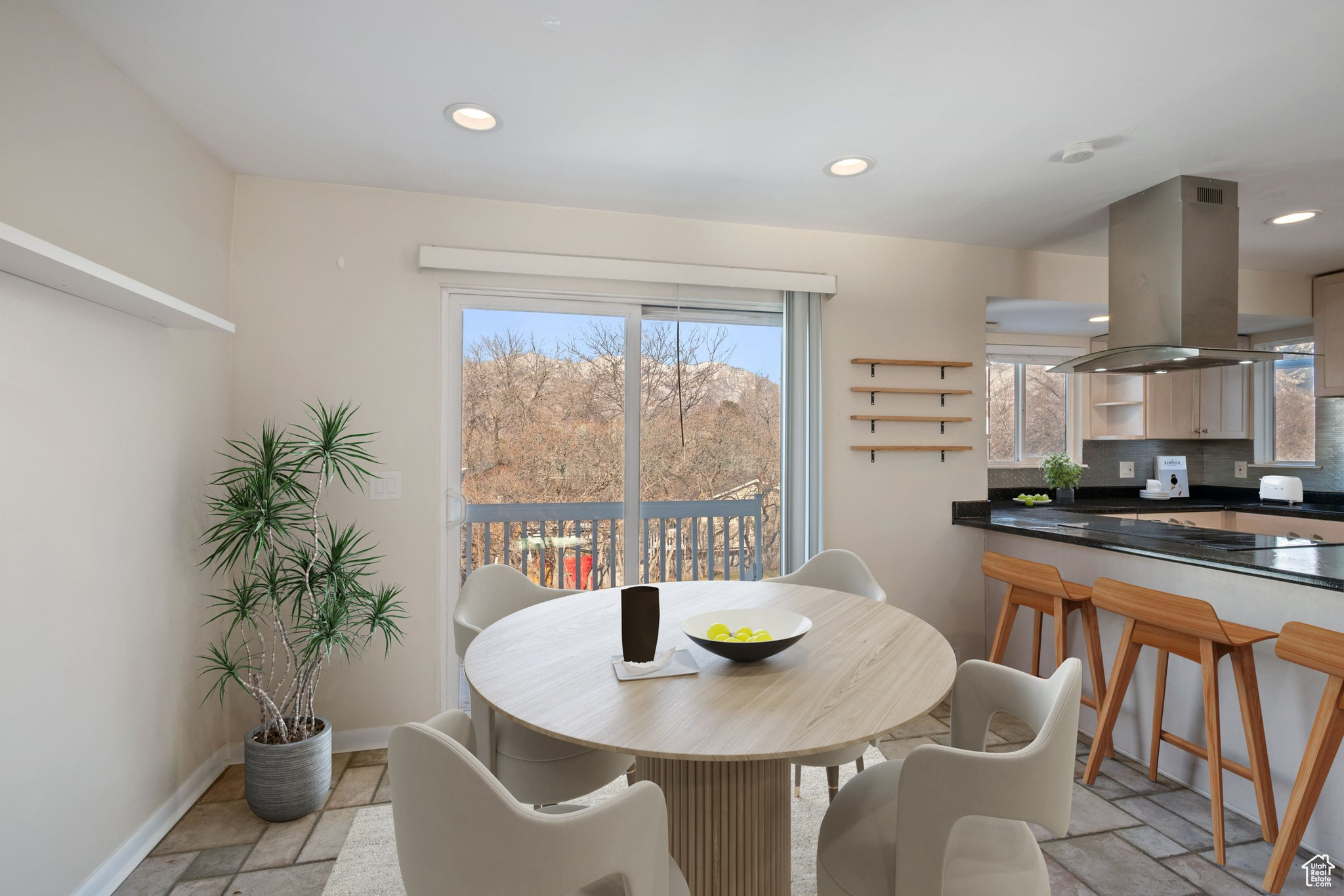 Dining space with baseboards, stone tile flooring, and recessed lighting