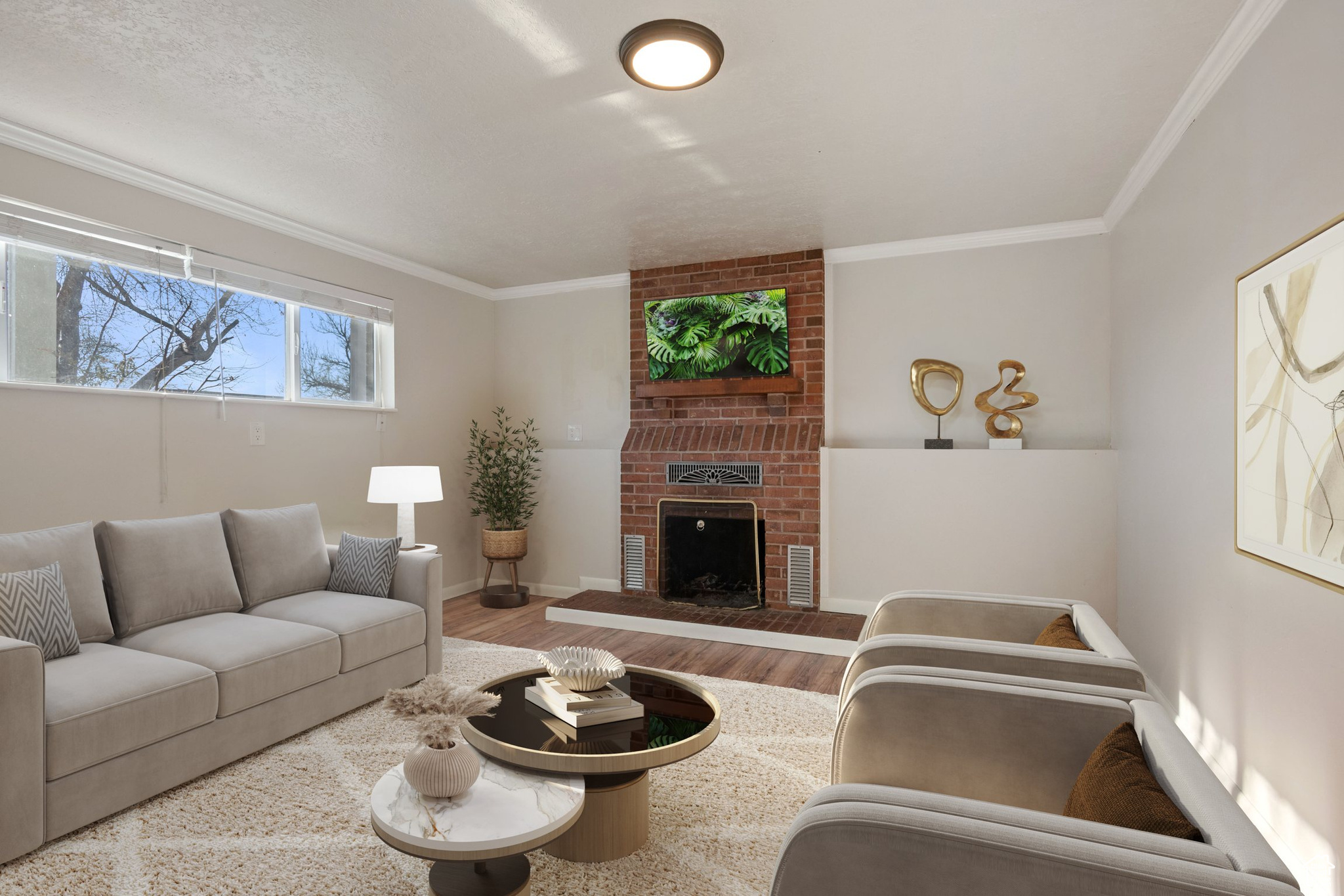 Living room with ornamental molding, a brick fireplace, baseboards, and wood finished floors