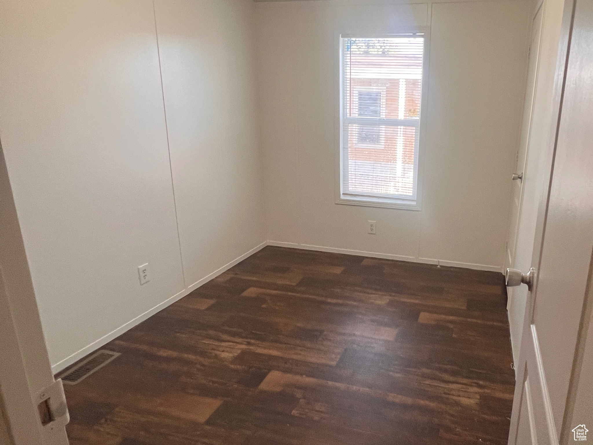 Spare room featuring a textured ceiling and dark wood-style floors