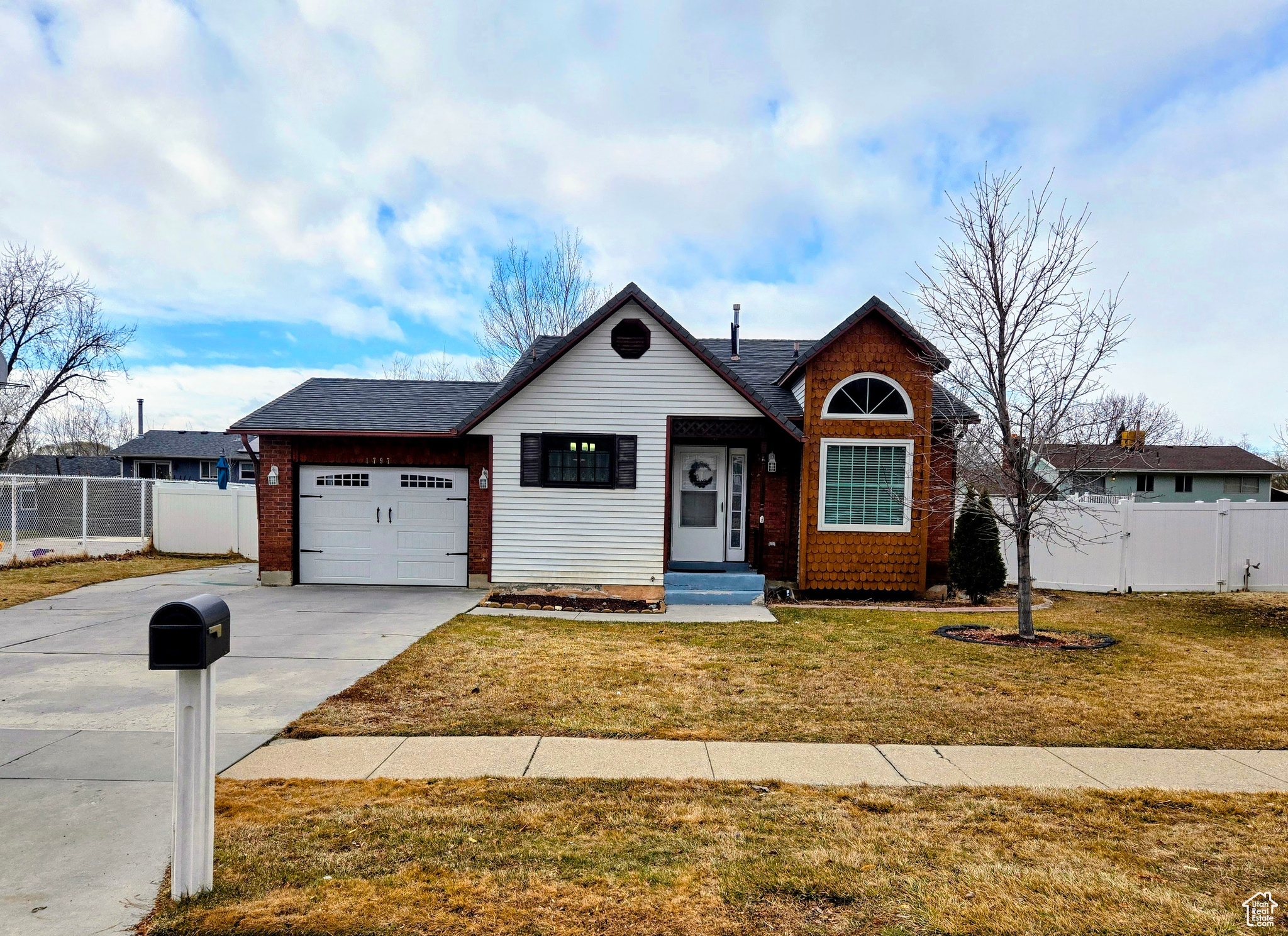 View of front of property featuring a garage and a front lawn