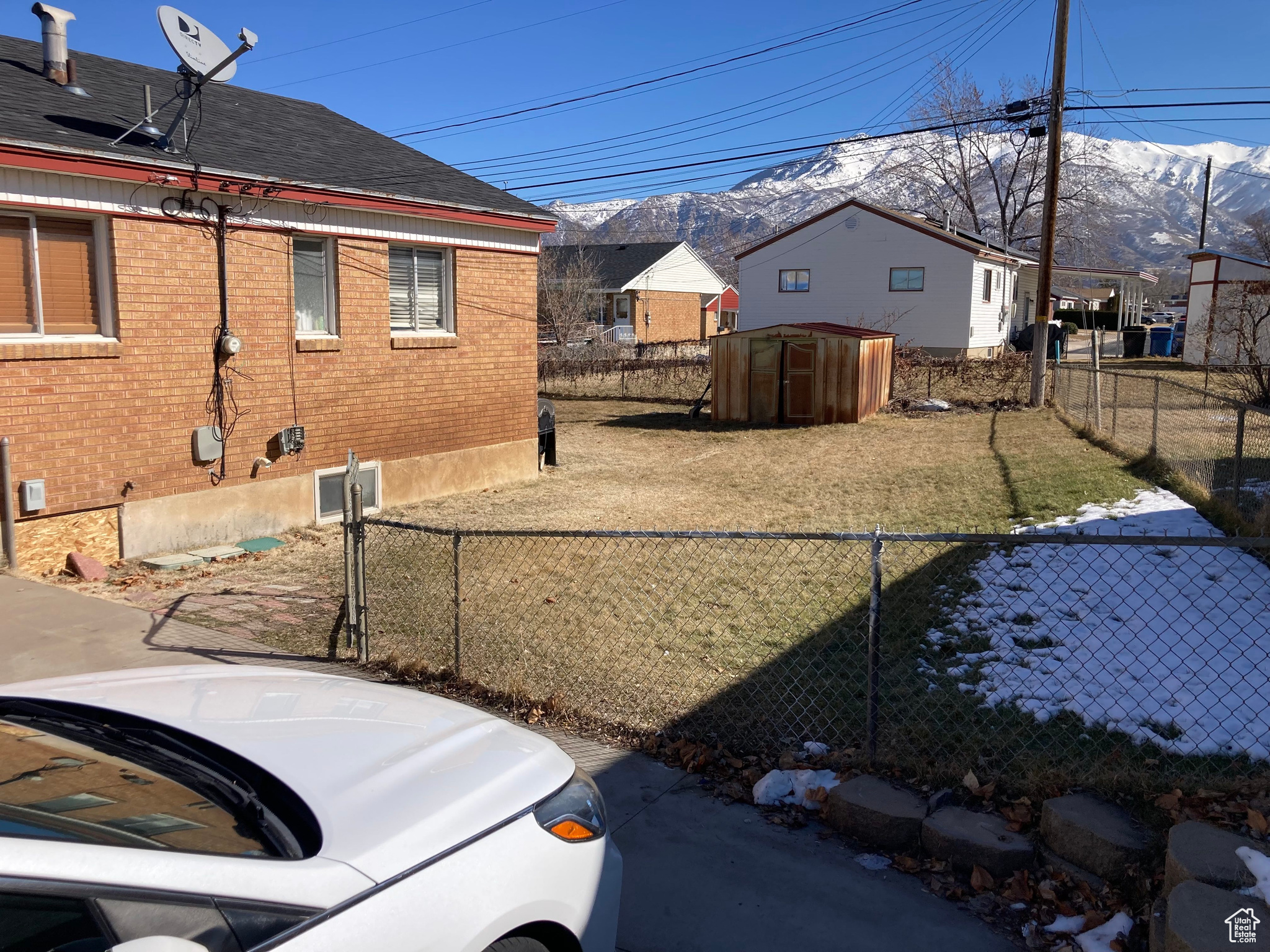 View of yard featuring an outbuilding, a storage unit, a fenced backyard, and a mountain view