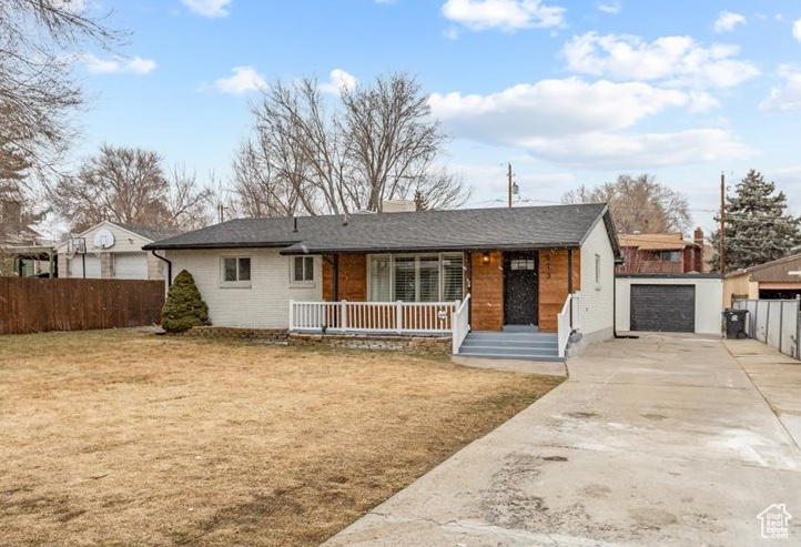 Ranch-style house with a porch, a garage, and a front yard