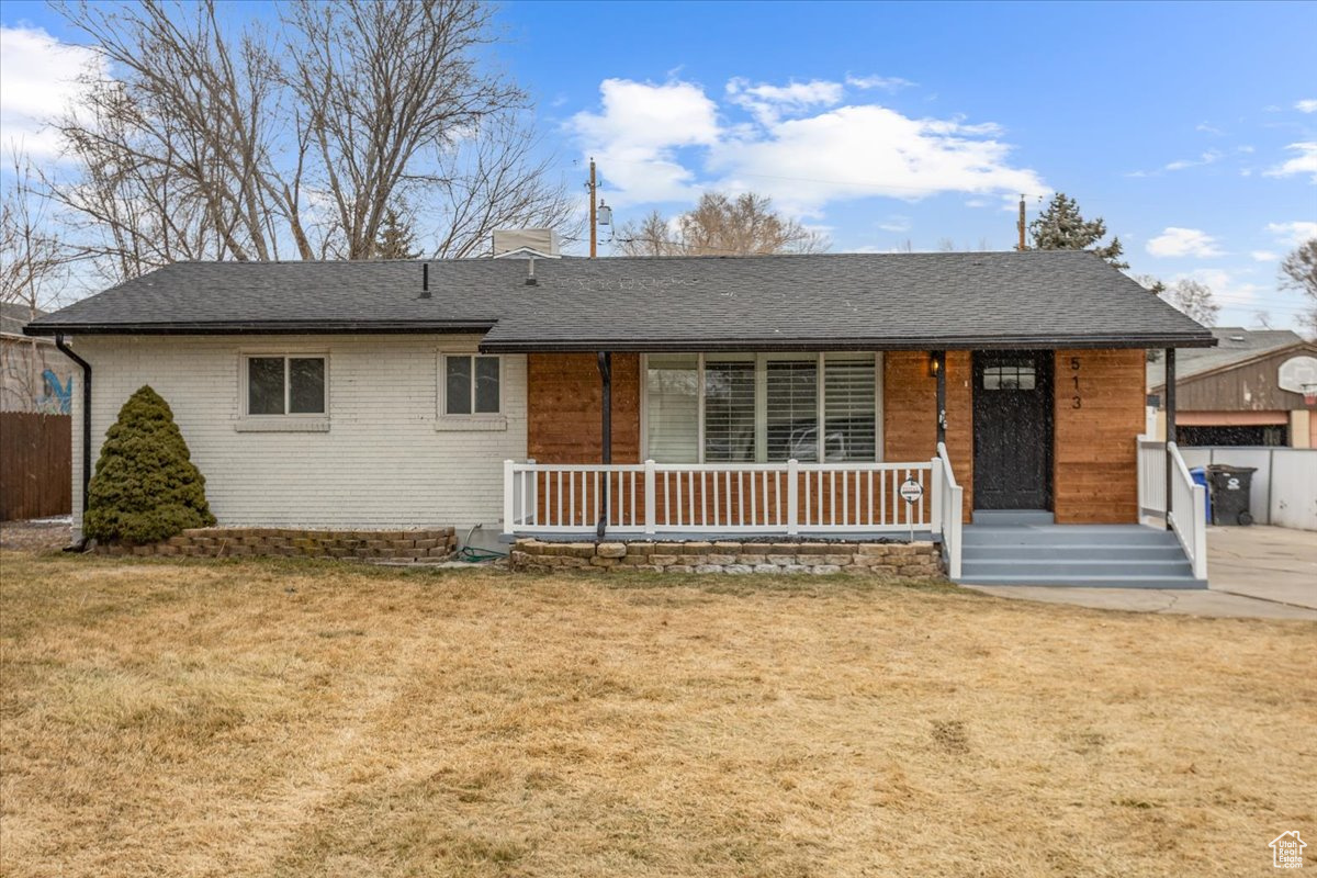Ranch-style home featuring a front yard and covered porch