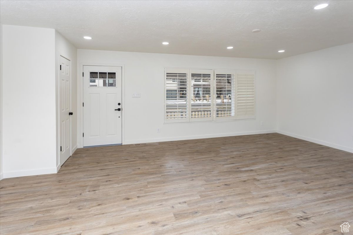 Foyer with light hardwood / wood-style flooring and a textured ceiling
