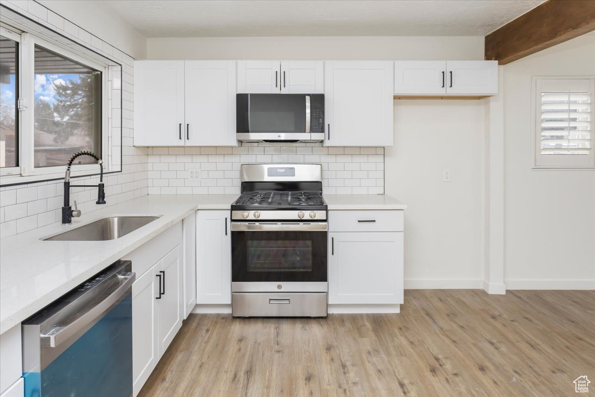 Kitchen featuring white cabinetry, appliances with stainless steel finishes, and sink