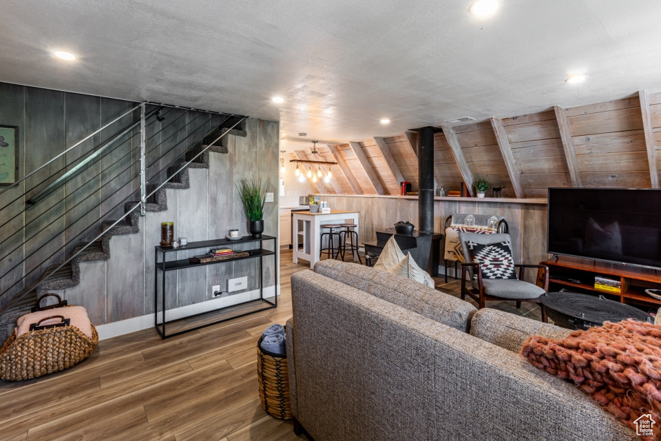 Living room featuring wood walls, wood-type flooring, and a wood stove
