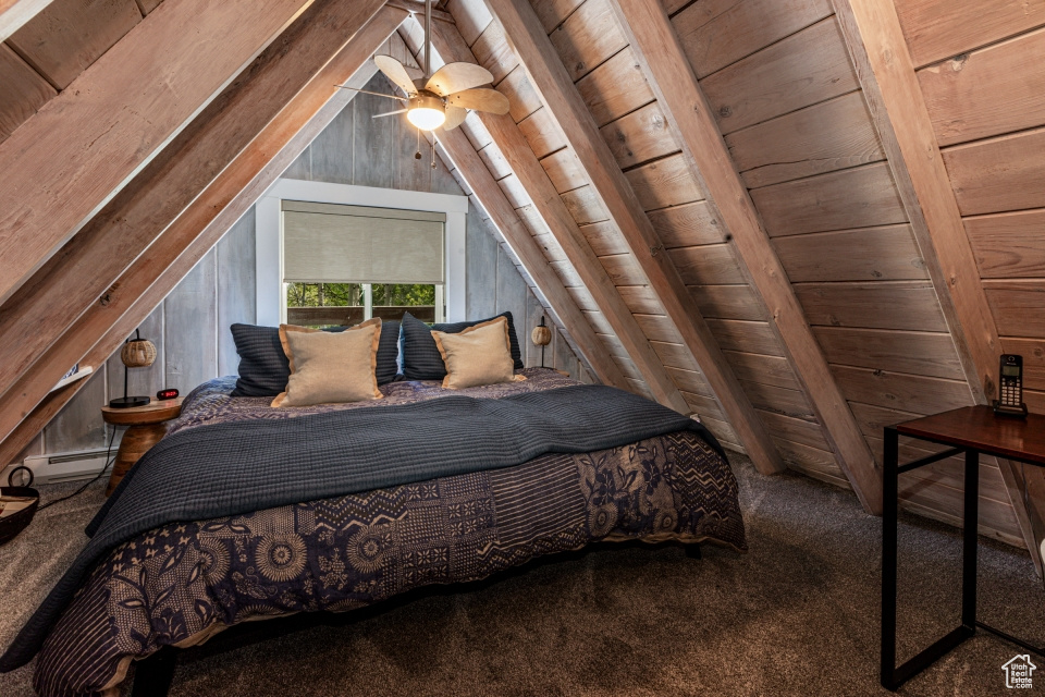 Carpeted bedroom featuring vaulted ceiling with beams, wooden ceiling, wooden walls, and a baseboard heating unit