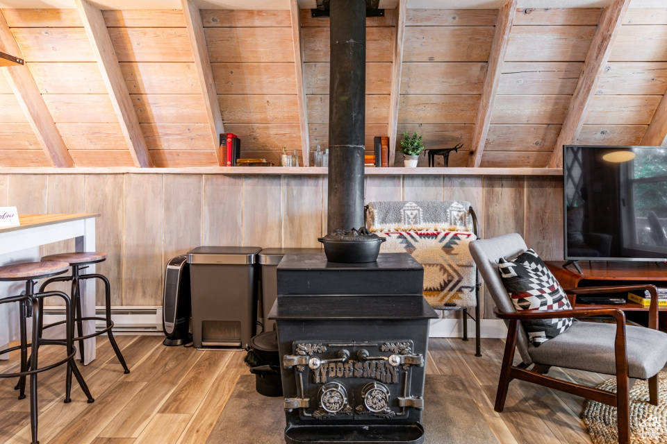 Interior details with hardwood / wood-style flooring, a wood stove, and wood walls
