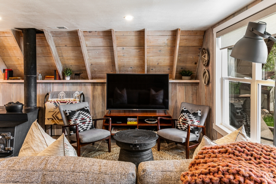 Living room with wood walls and a wood stove