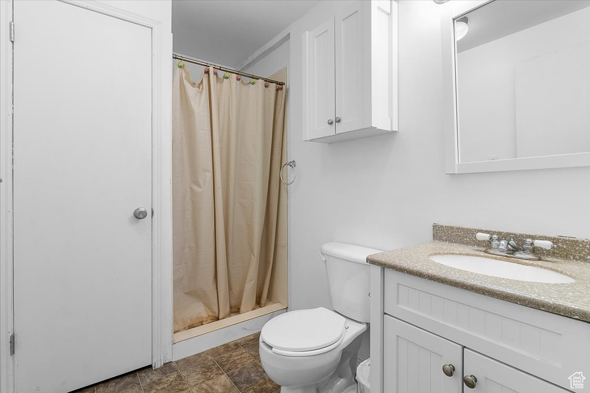 Bathroom with walk in shower, vanity, and toilet