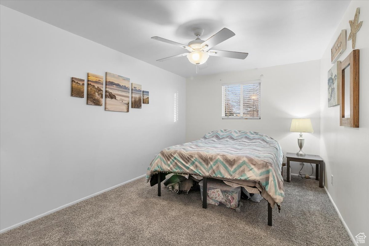 Bedroom featuring ceiling fan and carpet
