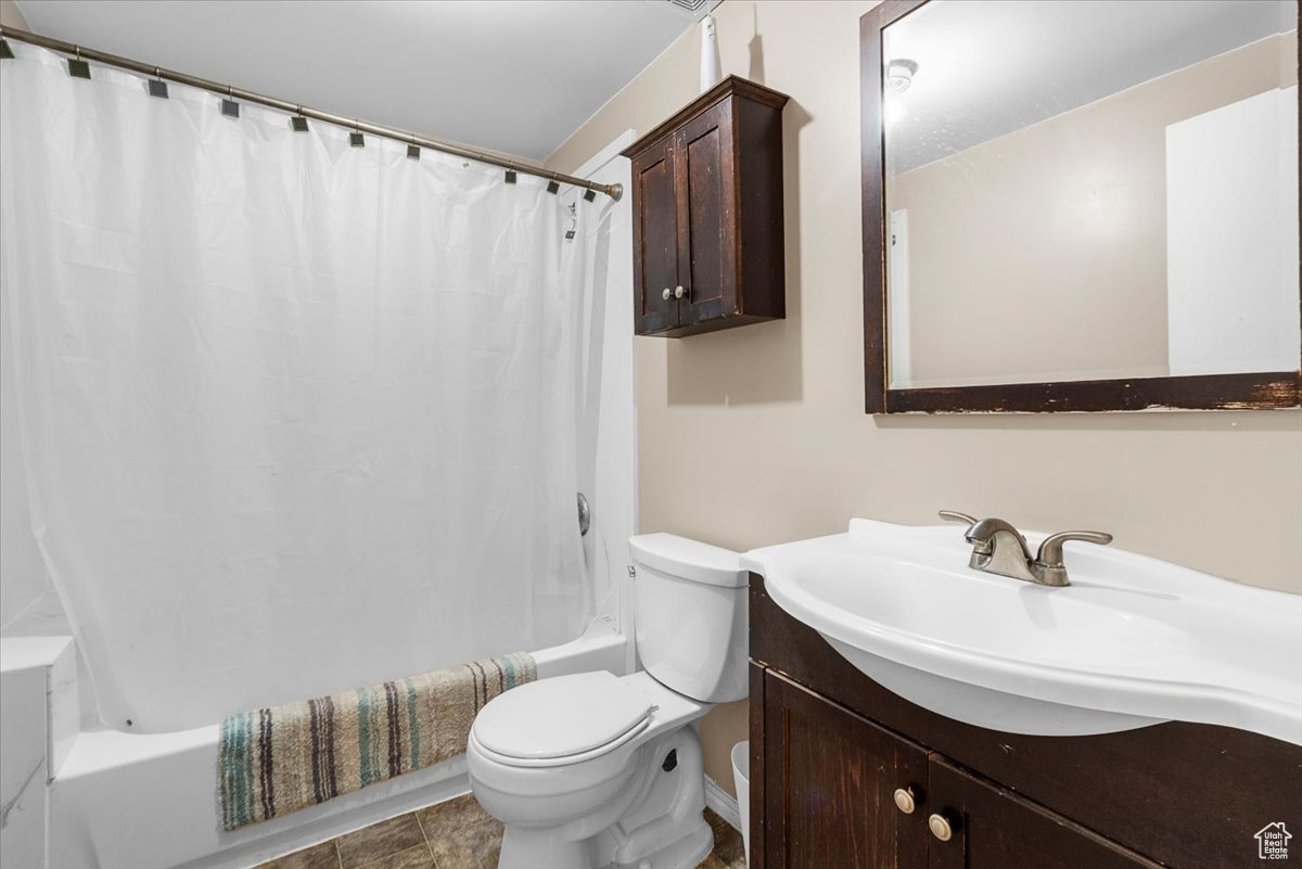 Full bathroom featuring vanity, shower / tub combo, and toilet