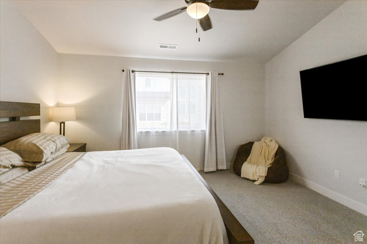 Carpeted bedroom with ceiling fan