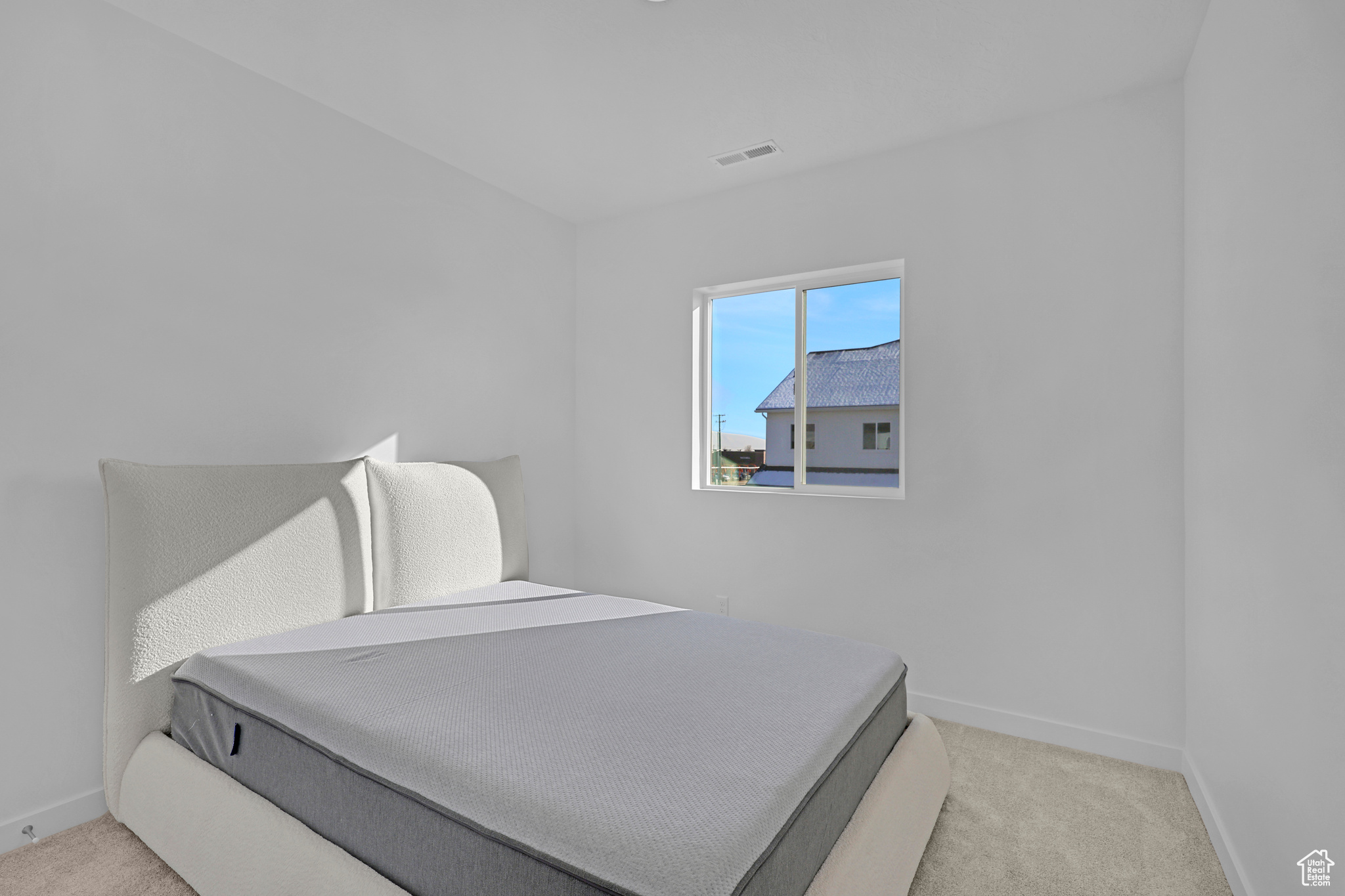 Bedroom featuring light carpet