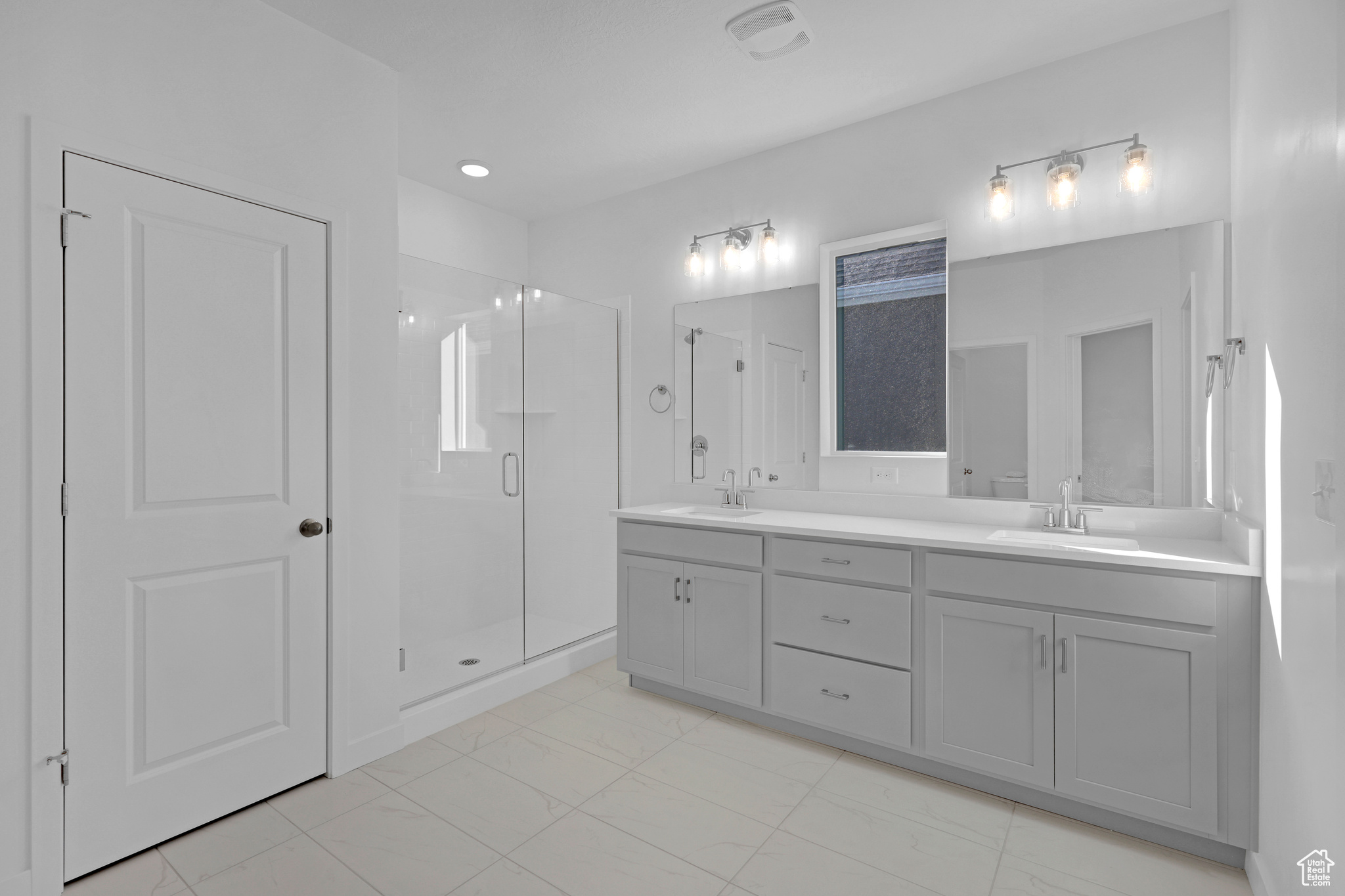 Bathroom with vanity and a shower with shower door