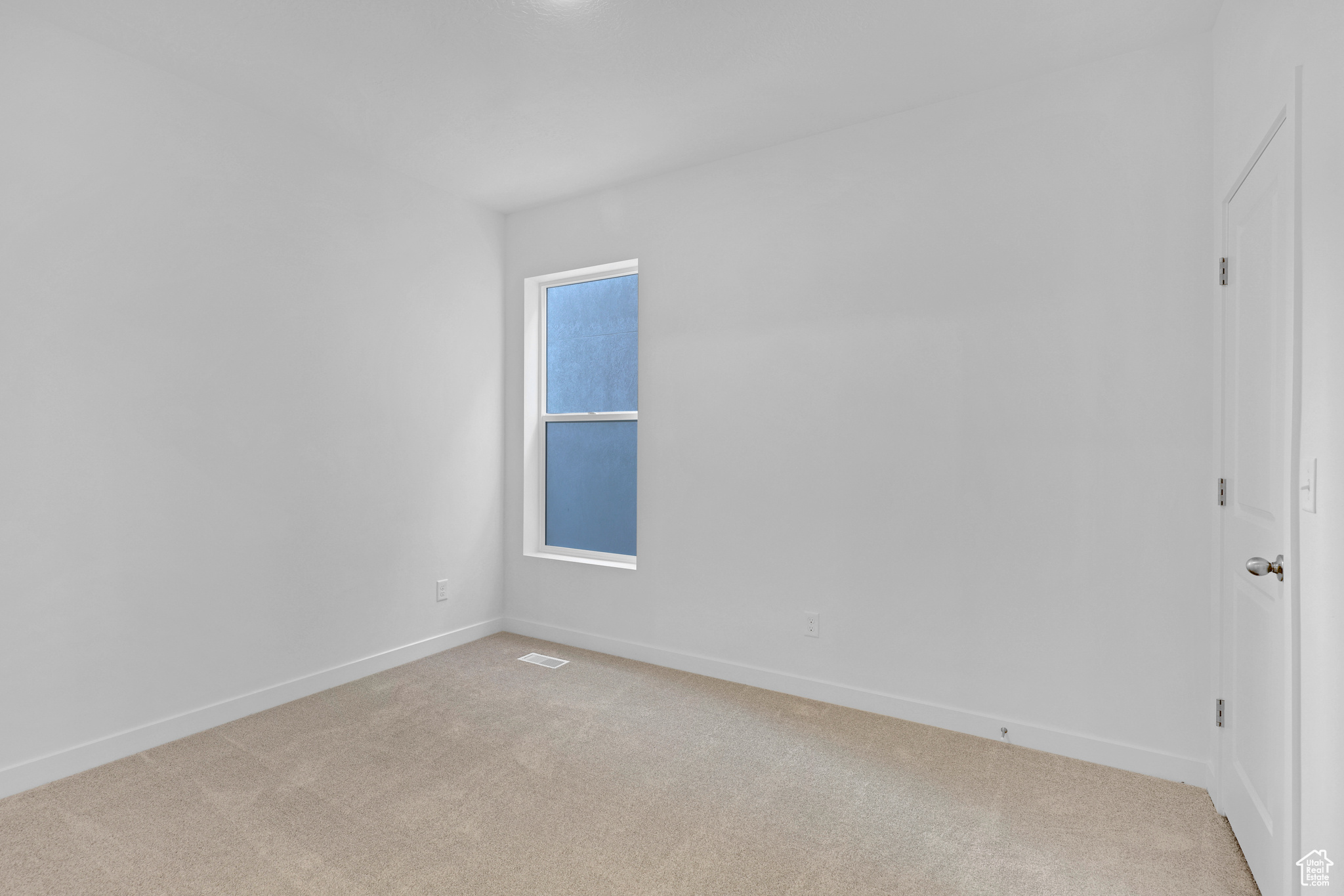 Spare room featuring light colored carpet