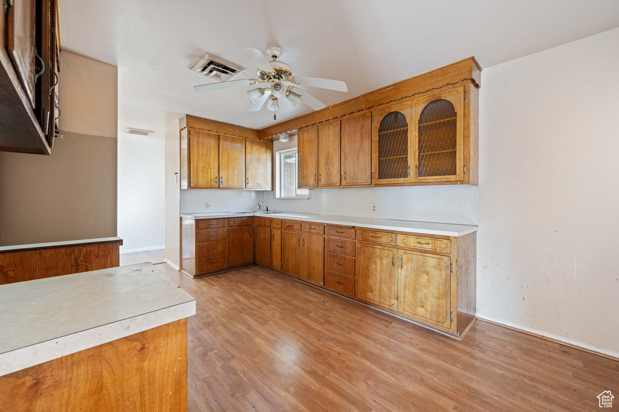 Kitchen with light hardwood / wood-style floors and ceiling fan
