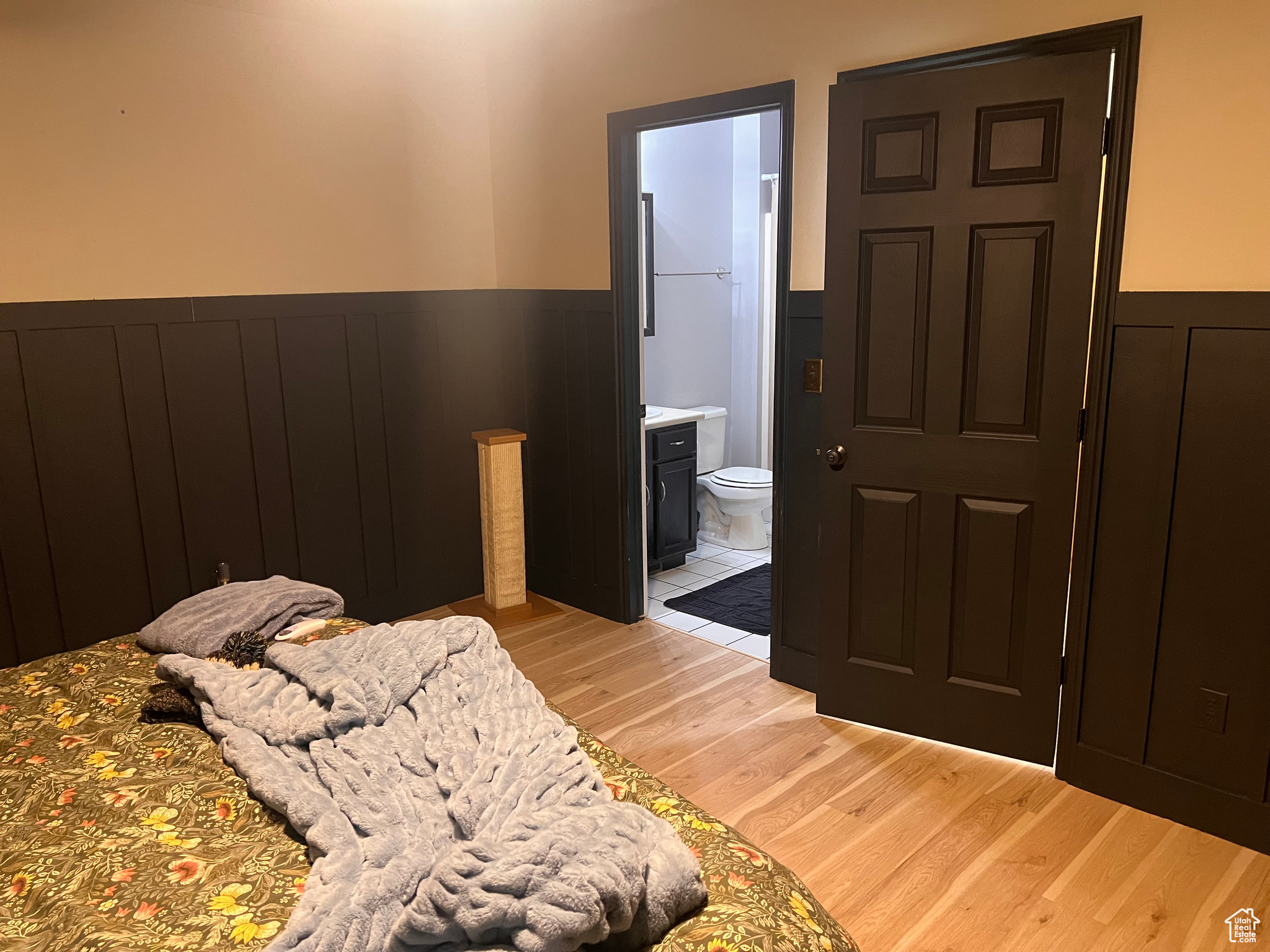 Bedroom with connected bathroom and light hardwood / wood-style flooring