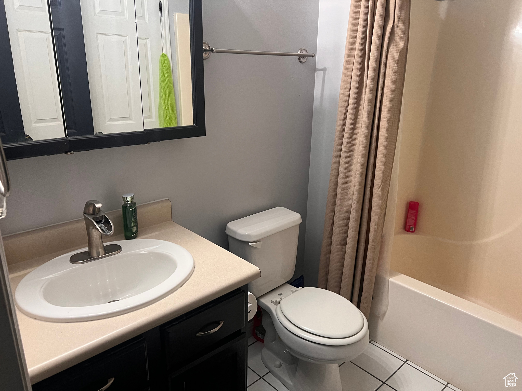 Full bathroom featuring vanity, tile patterned floors, shower / bath combination with curtain, and toilet