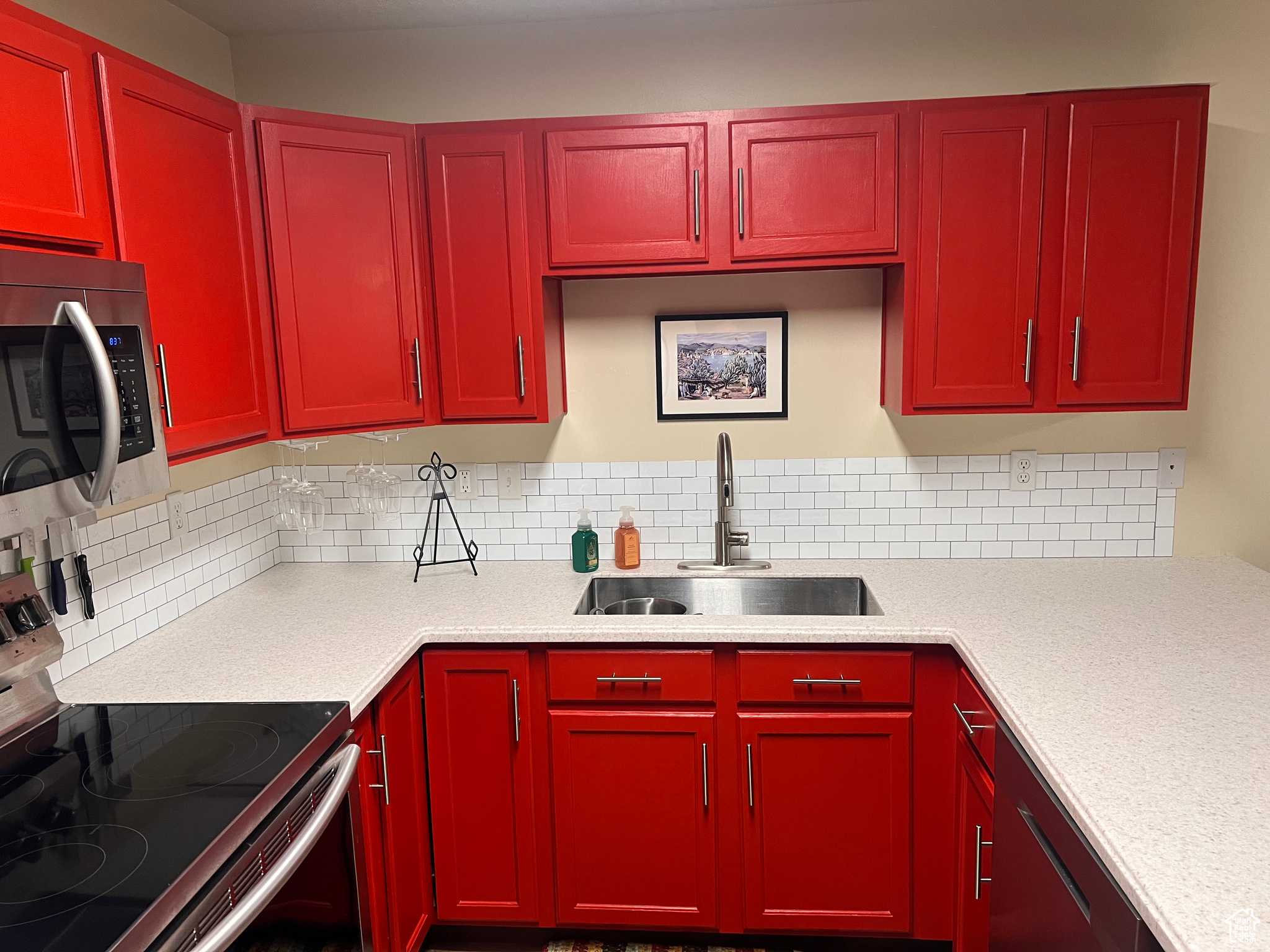 Kitchen with appliances with stainless steel finishes, sink, and backsplash
