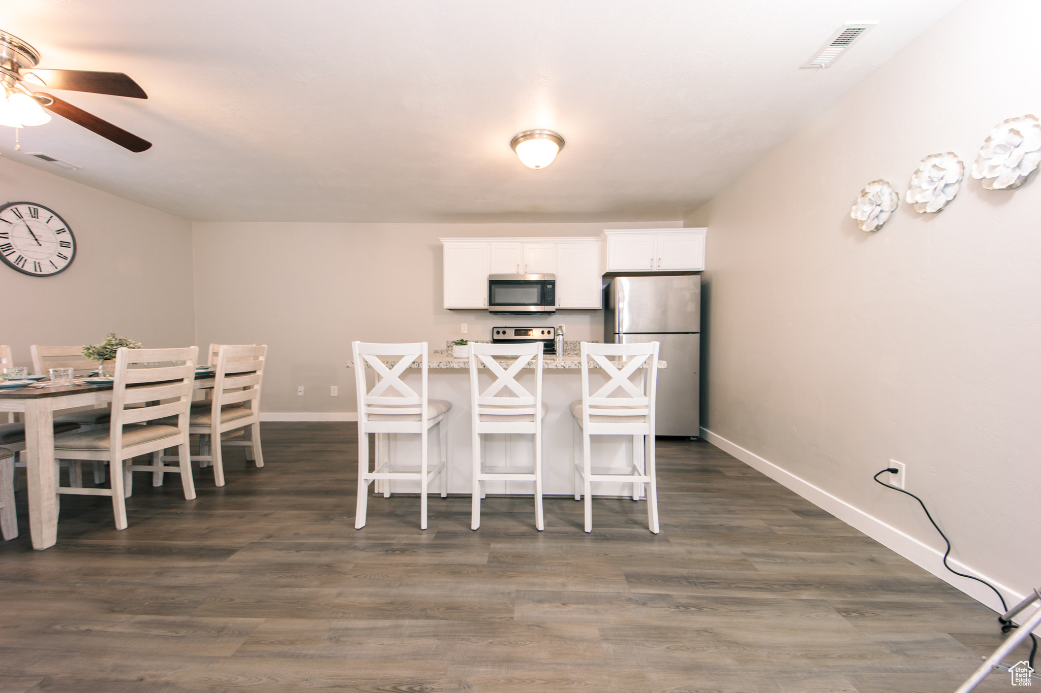 Dining area featuring dark wood-type flooring and ceiling fan