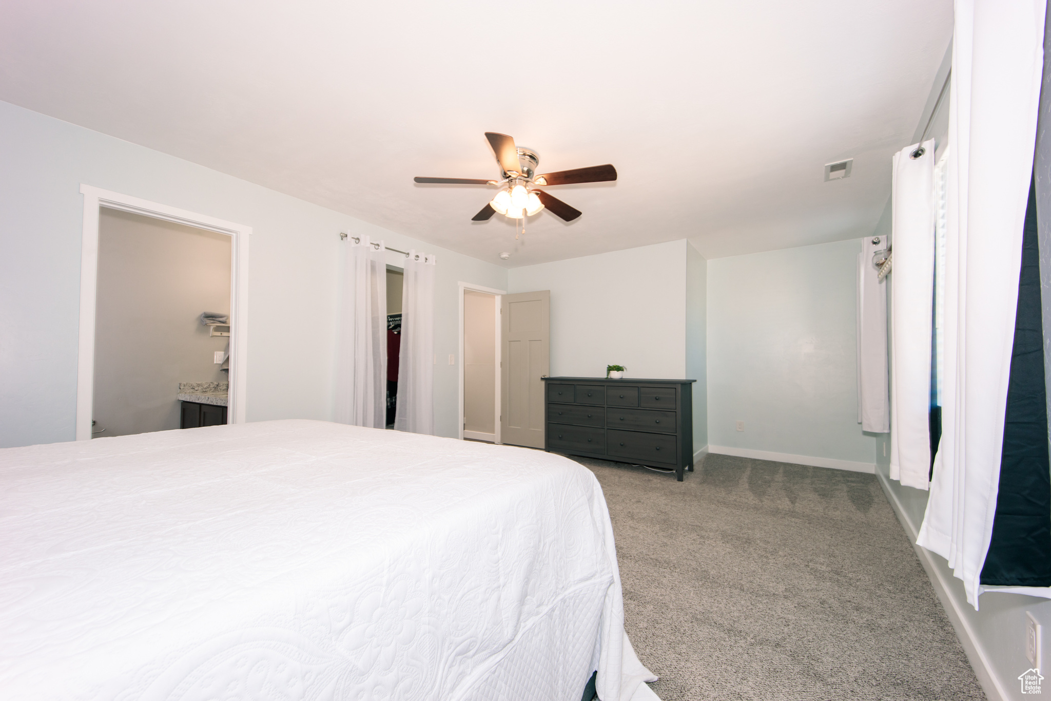 Carpeted bedroom featuring ceiling fan